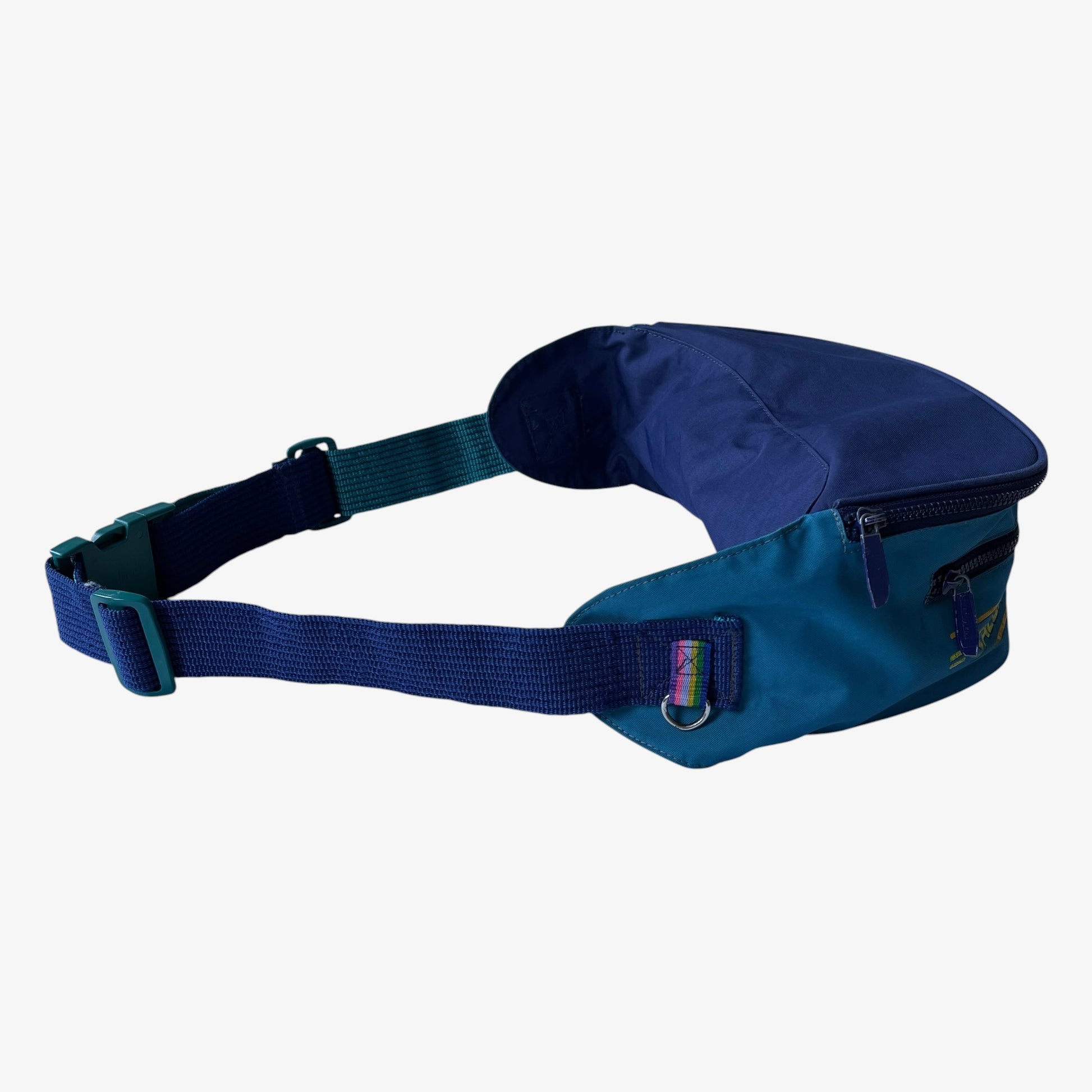 Right side view of extra large vintage Salomon blue fanny pack with a strap on a white background.