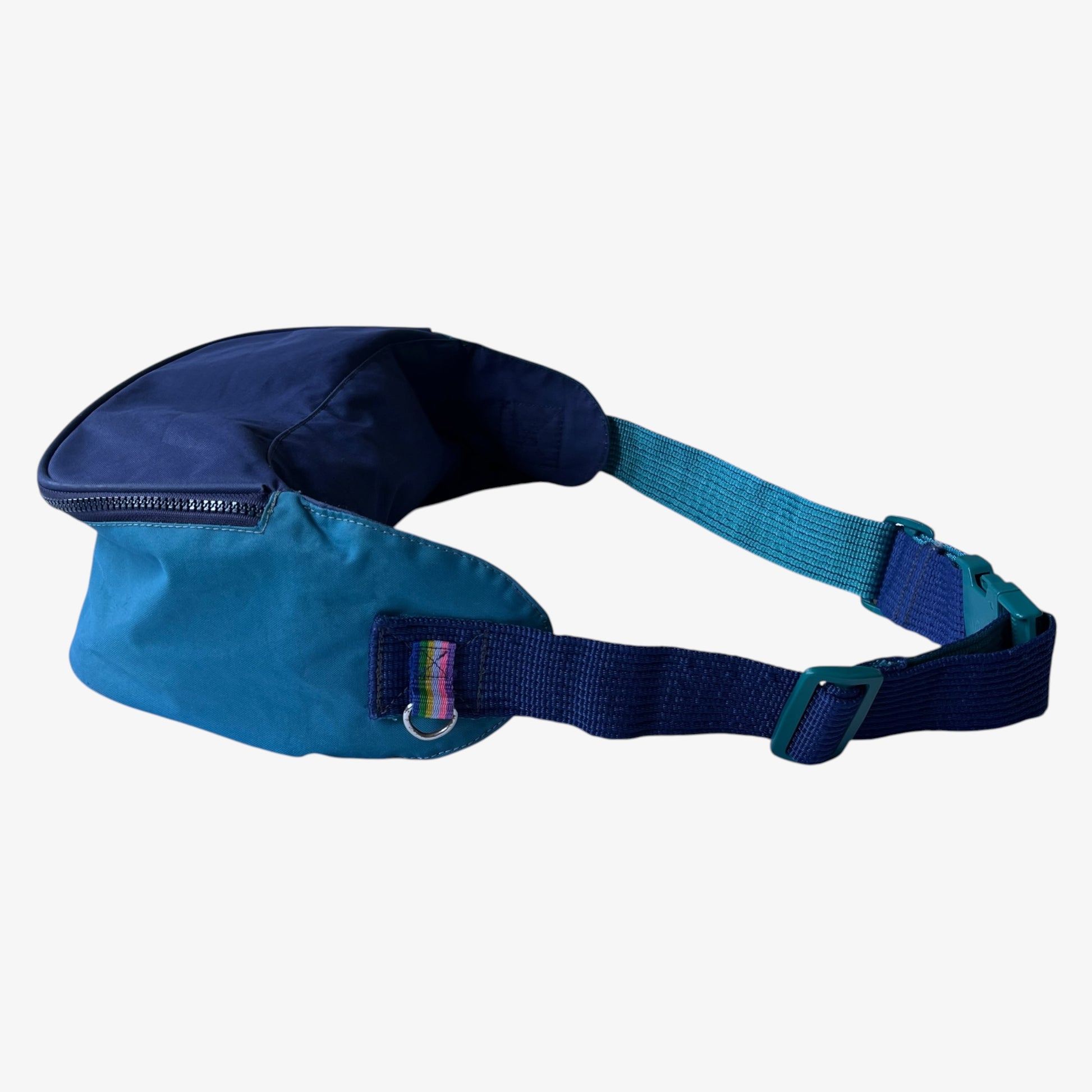 Side view of extra large vintage Salomon blue bum bag with a strap on a white background.