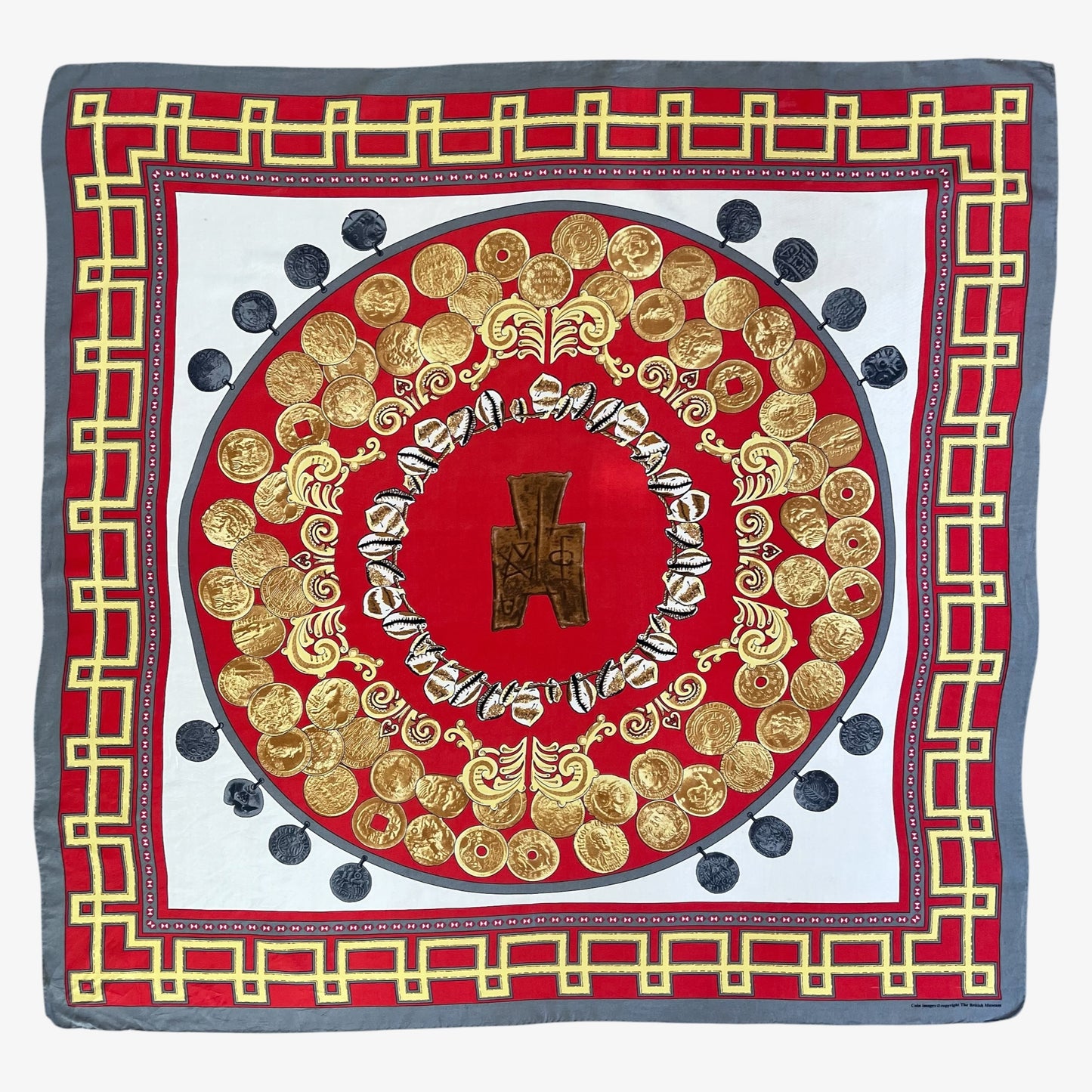 A square silk scarf featuring an intricate circular medallion design in red, gold, and white, framed by a grey border with a gold coin pattern.