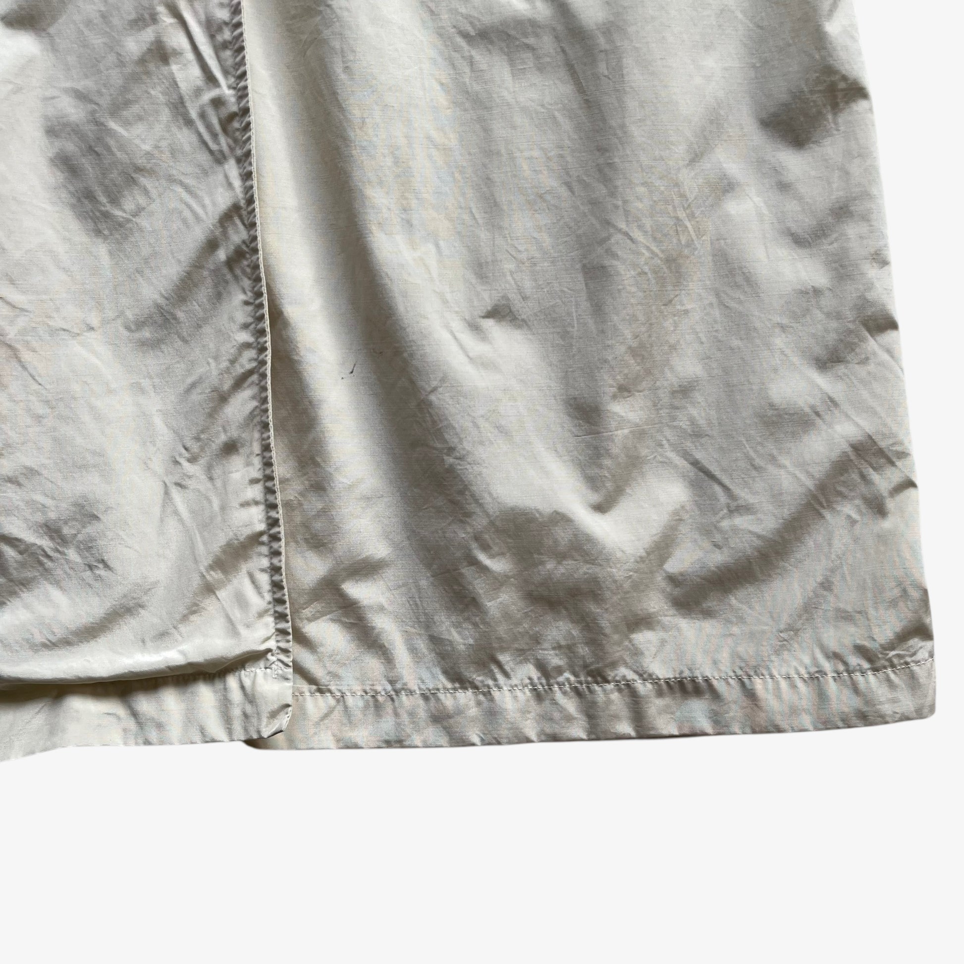 Hem of women's vintage 80s Burberry double breasted cream trench coat.