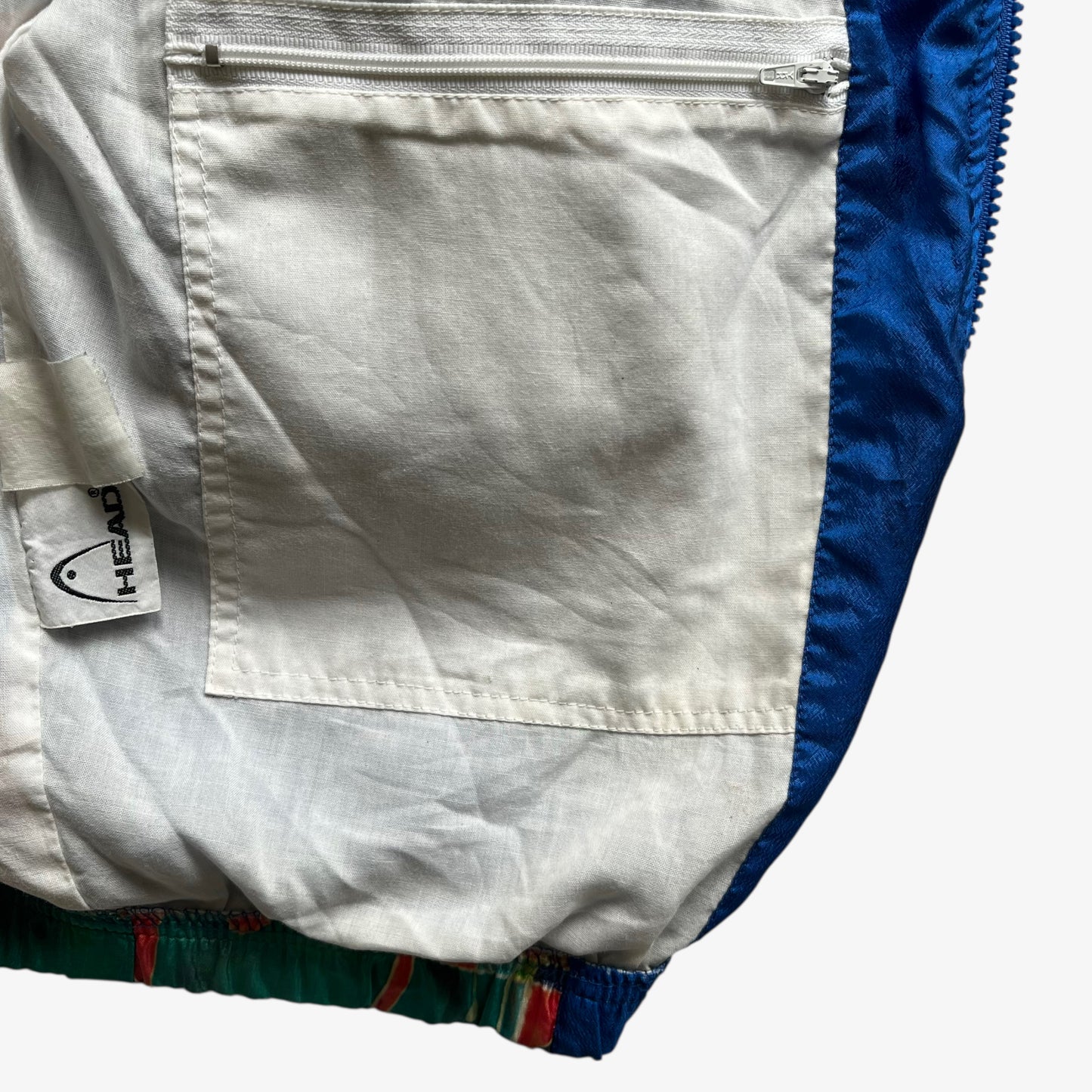Inside zipped pocket of vintage 80s women's Head abstract face print colourful track jacket with shoulder pads.