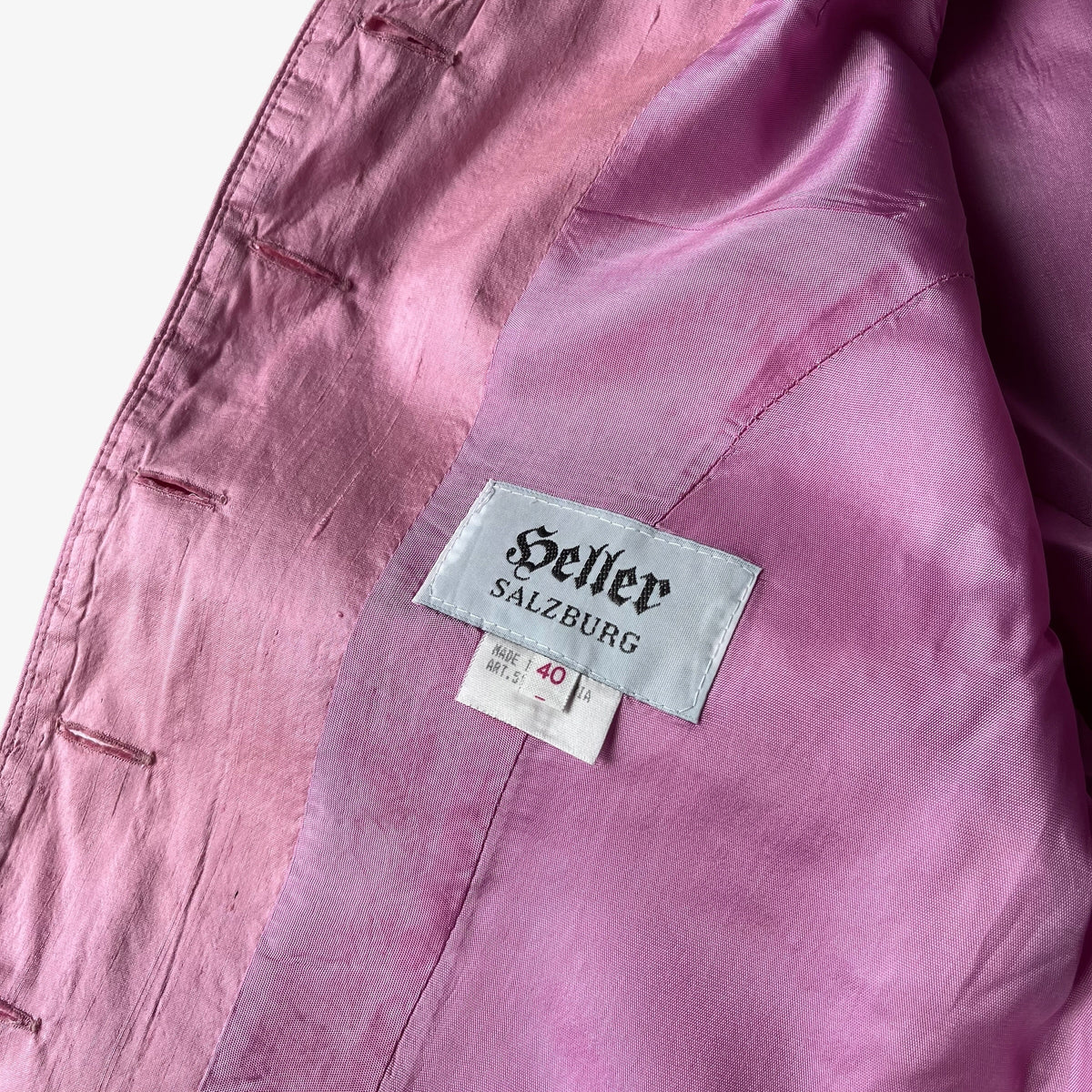 Close-up of a pink trachten jacket with a visible sewn label reading 'Heller Salzburg' and a size tag.