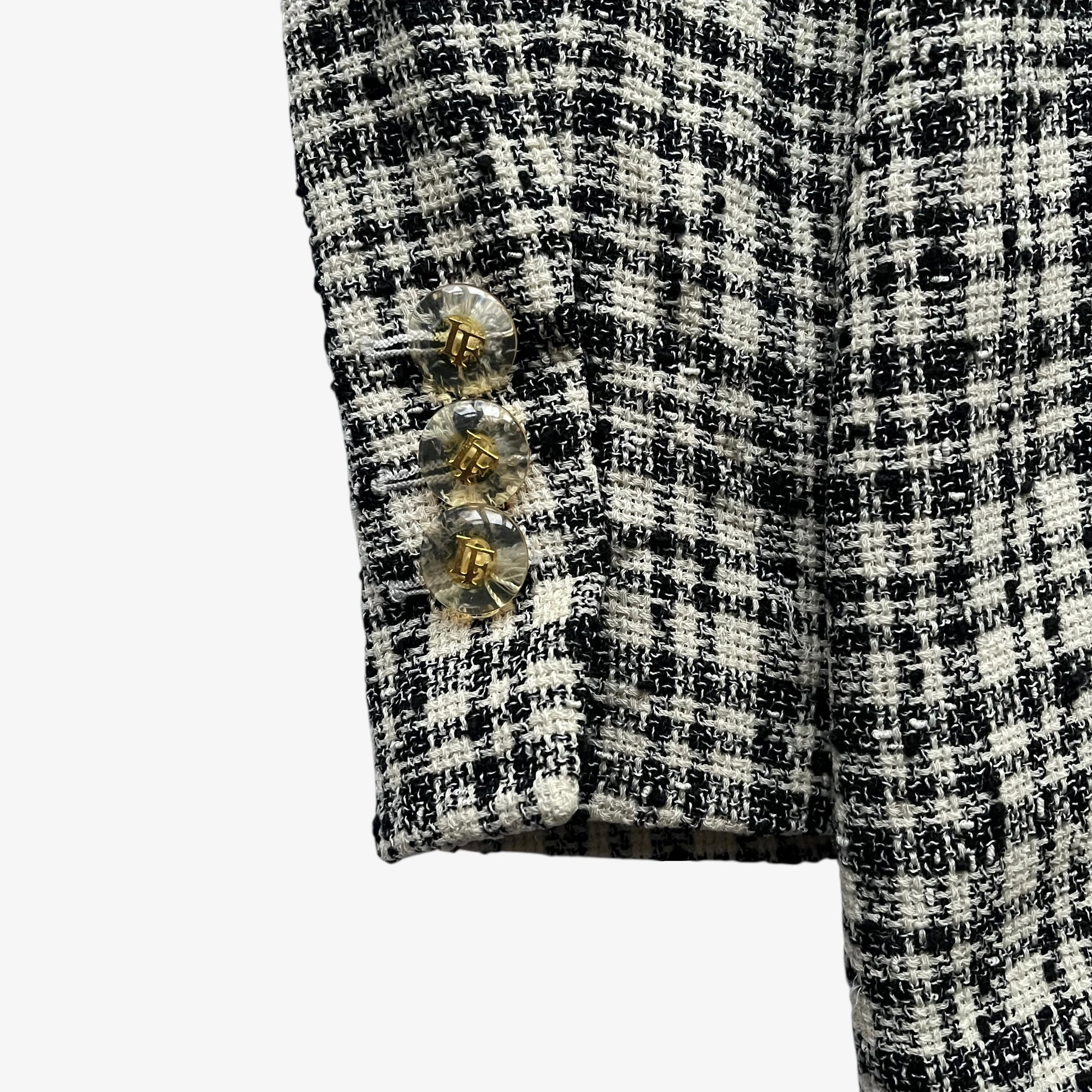 Pattern LF buttons on the cuff of a vintage 80s women's Louis Feraud cream and black striped tartan blazer.