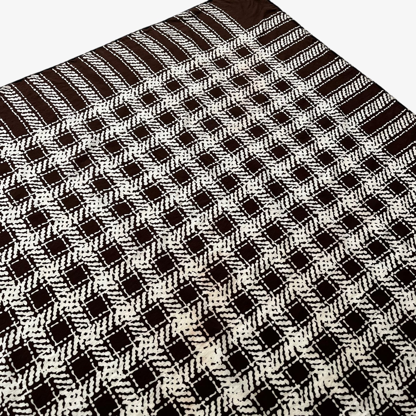 Patina on women's vintage 80s Yves Saint Laurent brown checkered print silk scarf with a YSL motif.
