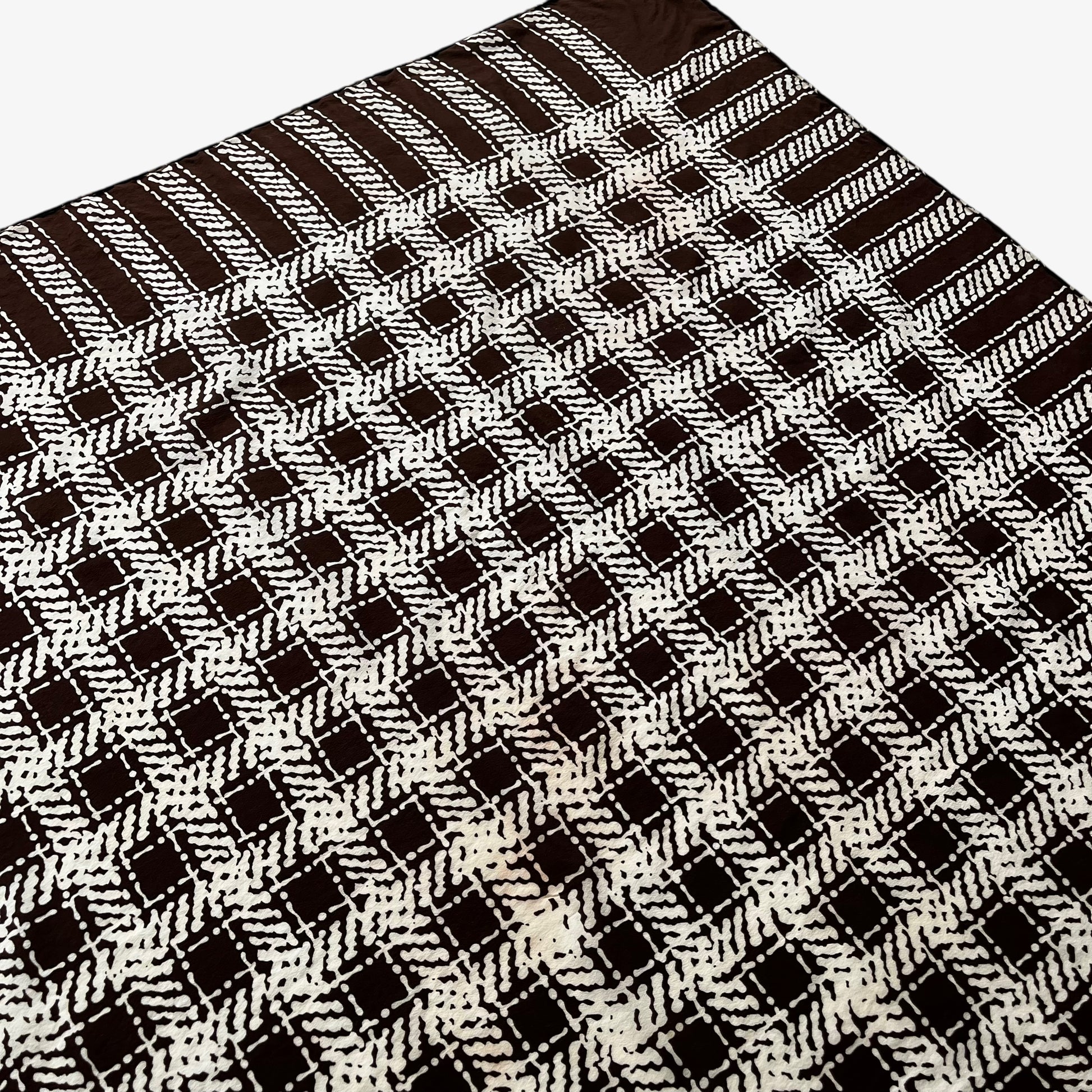 Patina on women's vintage 80s Yves Saint Laurent brown checkered print silk scarf with a YSL motif.