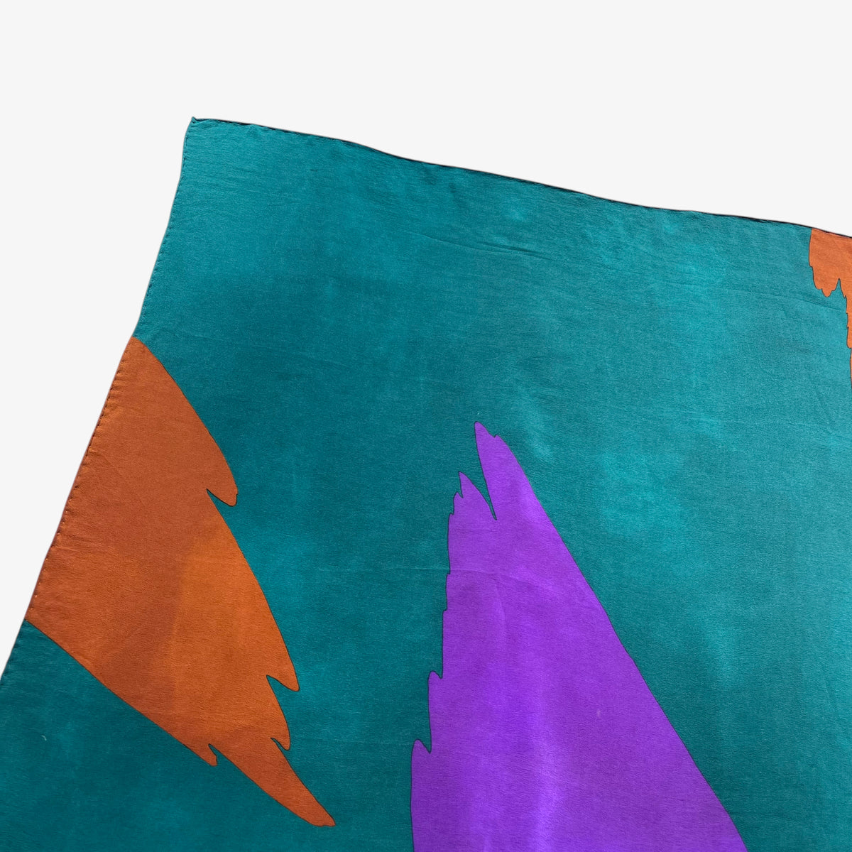 Fading on women's vintage 80s Yves Saint Laurent colourful abstract print green silk scarf.