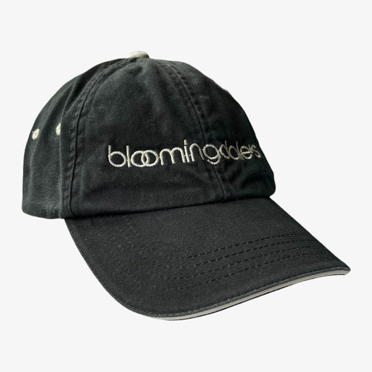 A black cotton baseball cap with Bloomingdale's embroidered in white across the front, shown on a light grey background.