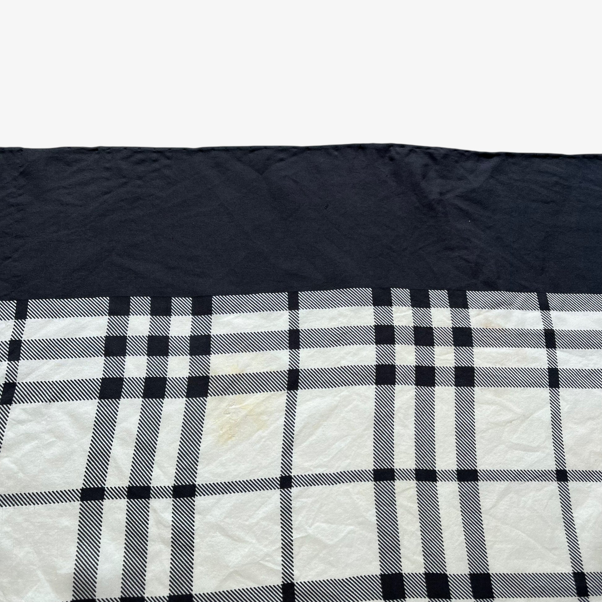Hem of women's vintage 90s Burberry black nova check print silk scarf.