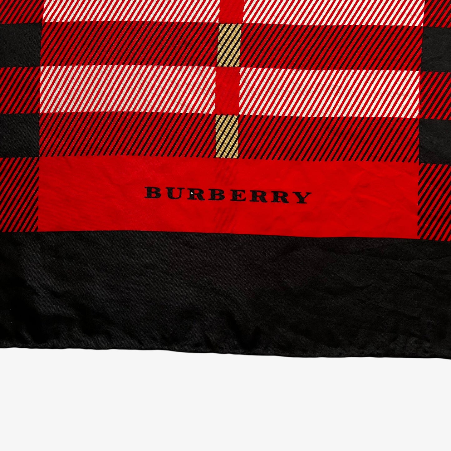 Burberry logo on the hem of a vintage 90s women's red nova check print silk scarf featuring a colourful plaid tartan pattern.