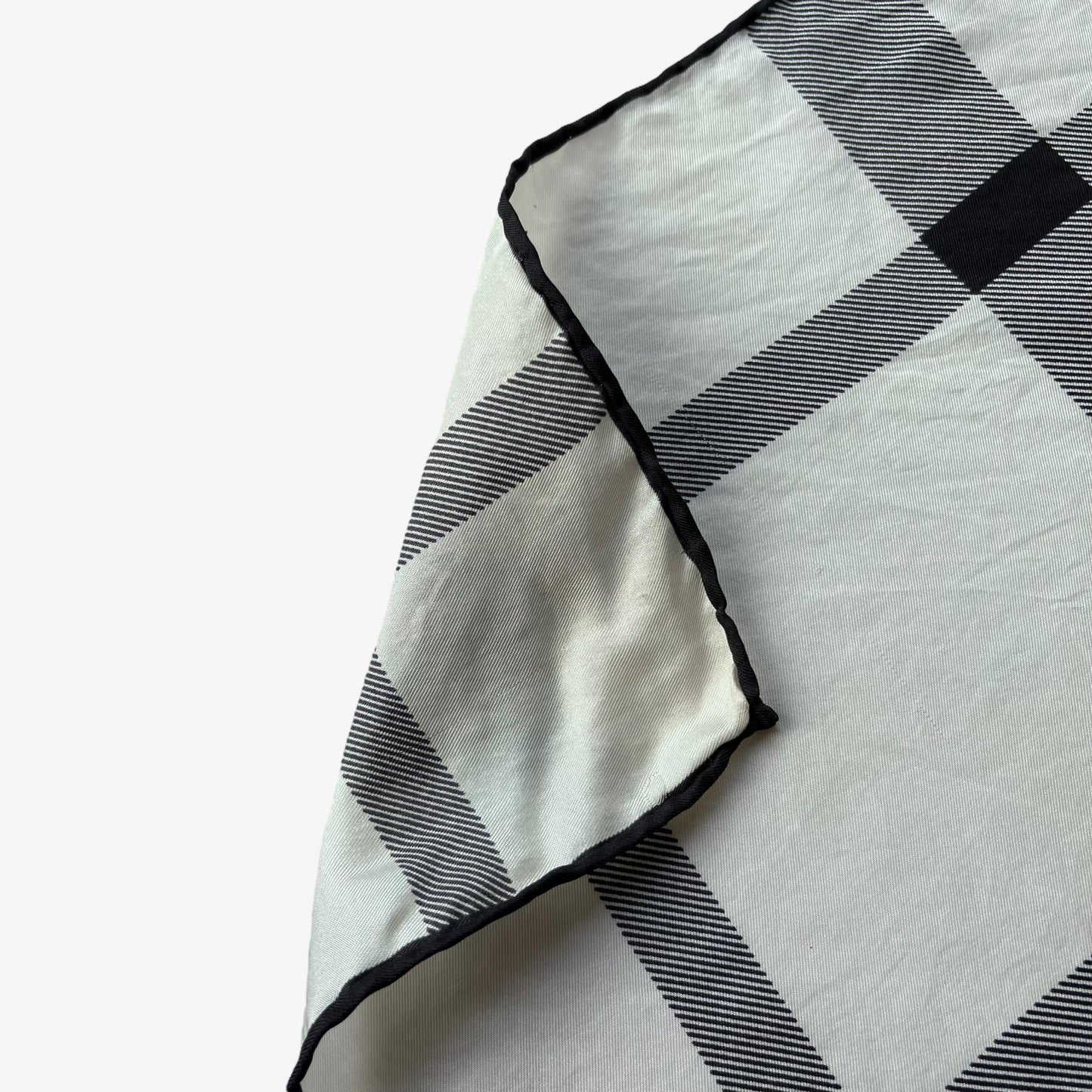 Hand rolled edges on women's vintage 90s Burberry white and black nova check print silk scarf.