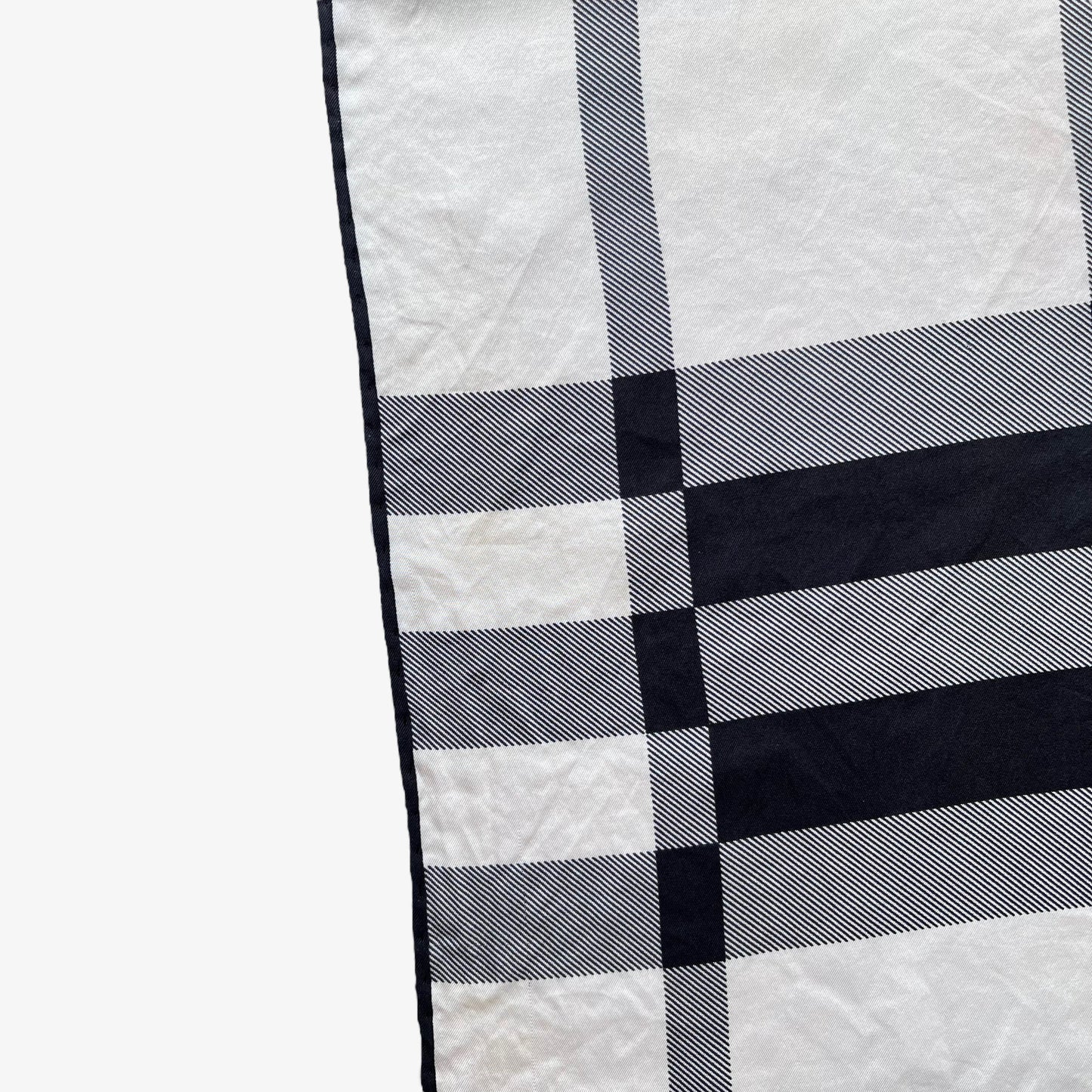 Hem on women's vintage 90s Burberry white and black nova check print silk scarf.