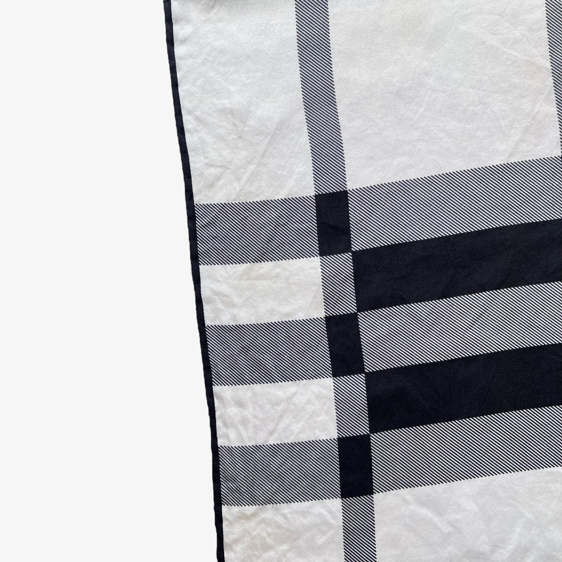 Hem on women's vintage 90s Burberry white and black nova check print silk scarf.