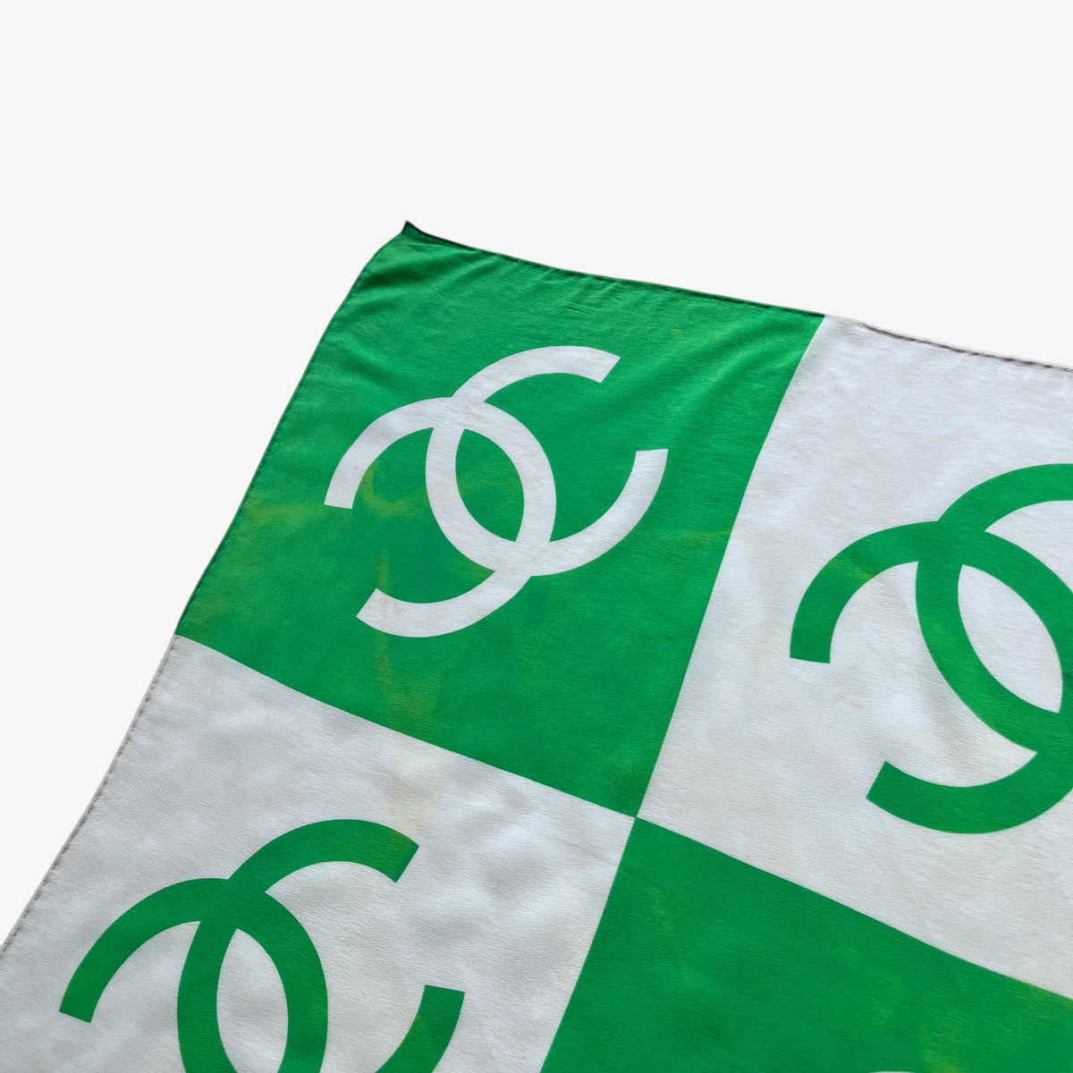 Hem on women's vintage 90s Chanel interlocking CC checkered print green silk scarf.