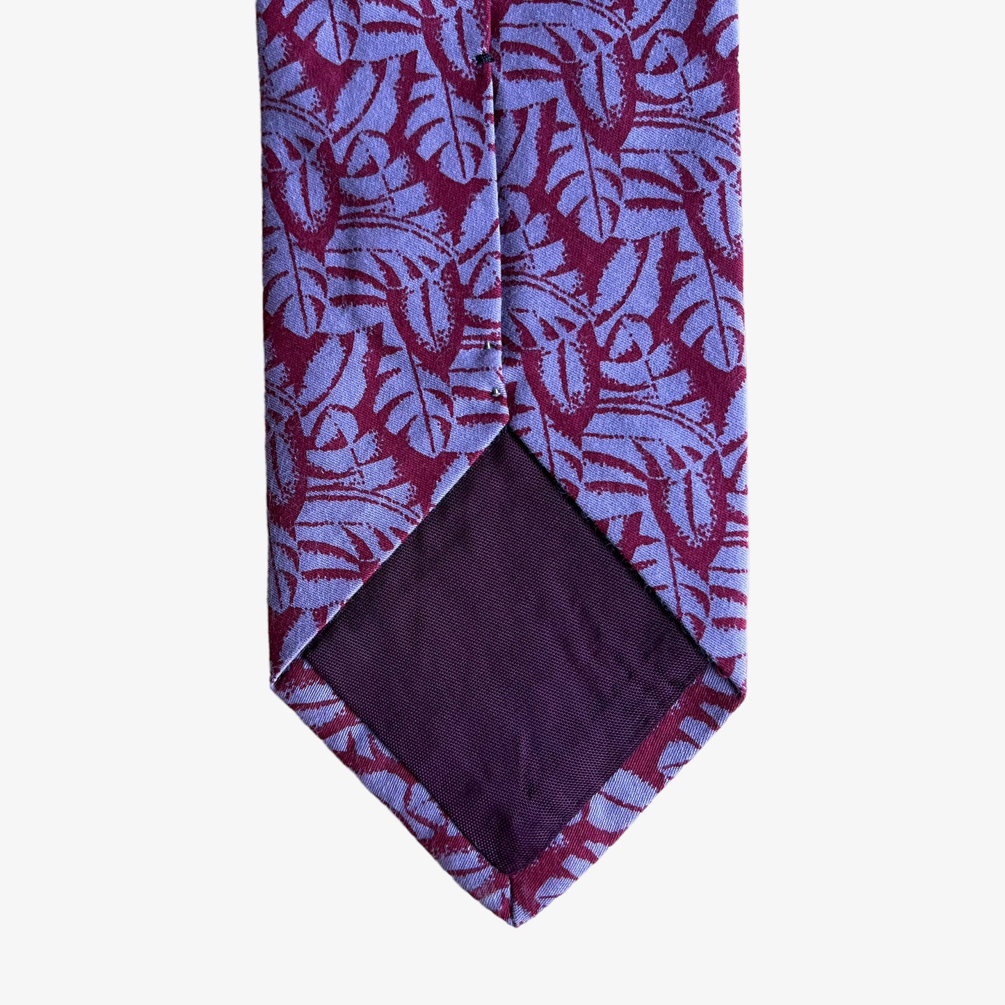 Back of vintage 90s Giorgio Armani red silk tie with a tropical leaf print pattern.