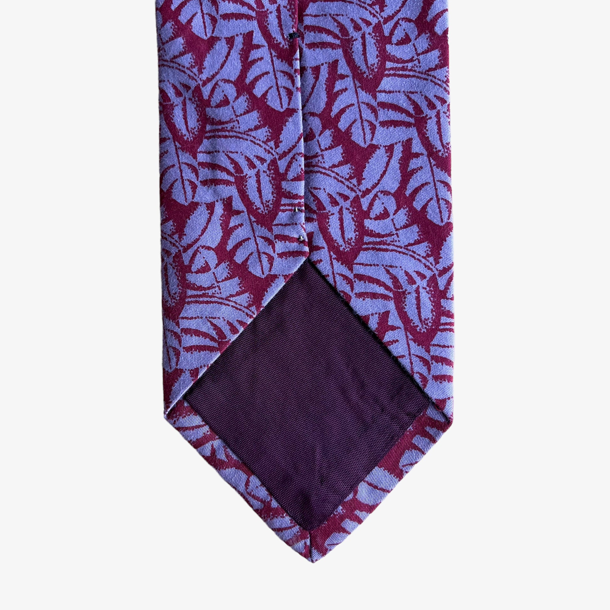 Back of vintage 90s Giorgio Armani red silk tie with a tropical leaf print pattern.
