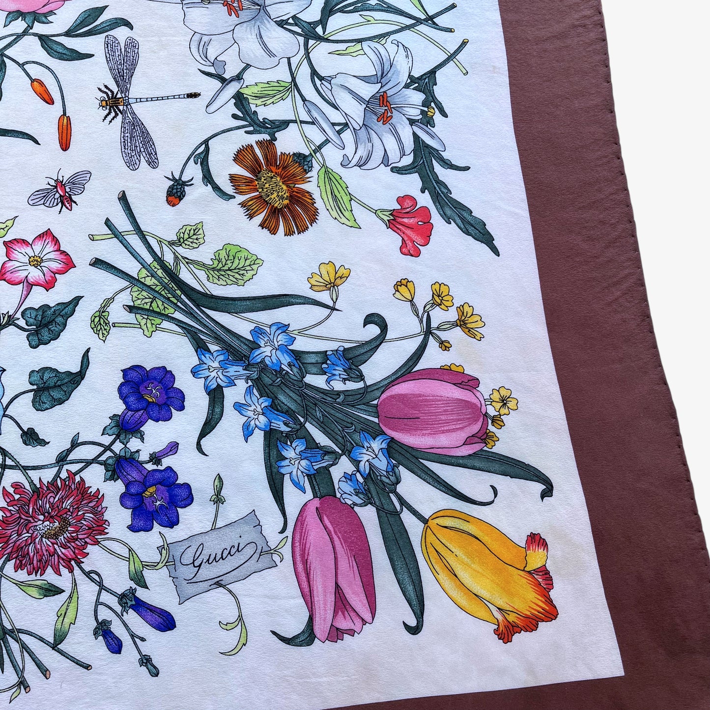 Logo on women's 90s vintage Gucci colourful floral and insect print brown silk scarf designed by Vittorio Accornero.