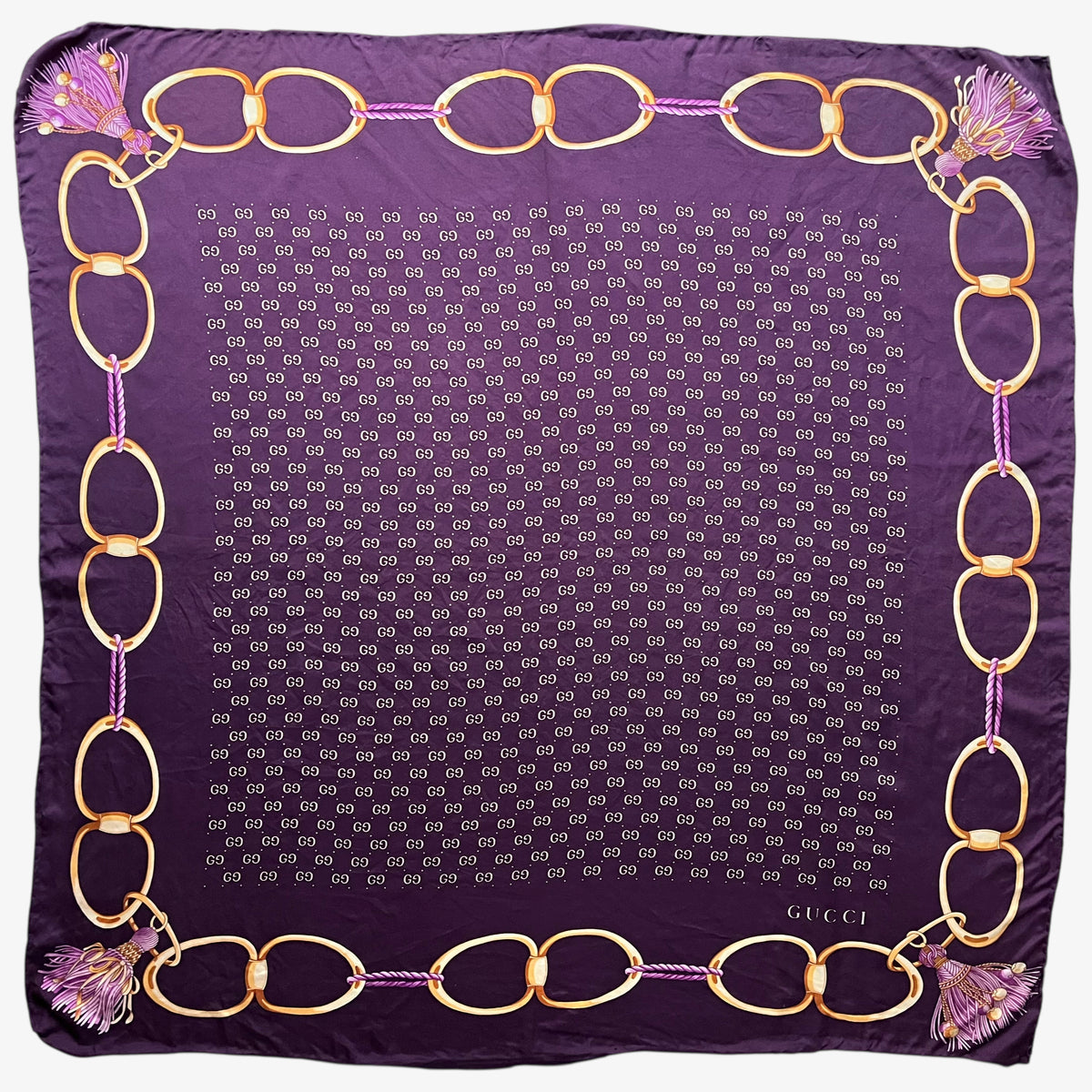 Women's vintage 90s Gucci gold tassel chain print purple silk scarf with a geometric interlocking GG pattern.