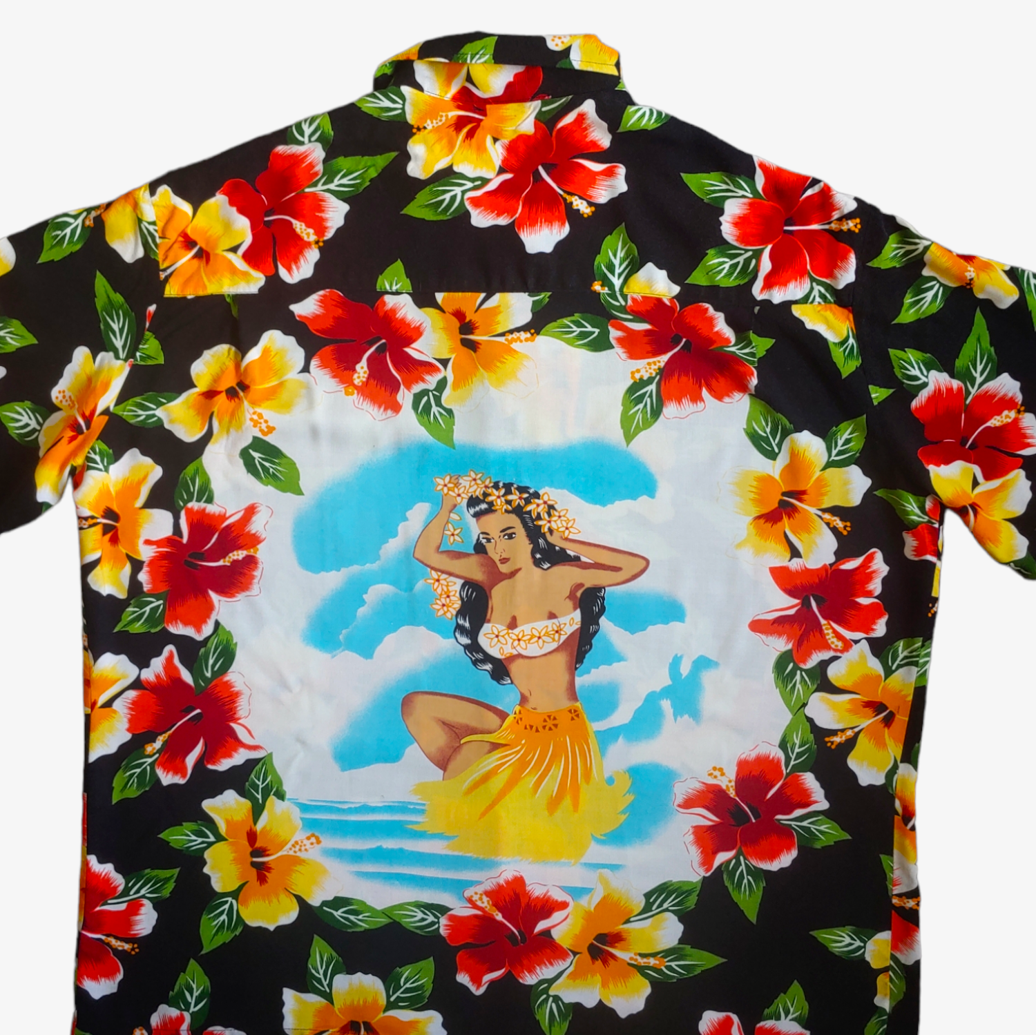 Close up of back printed tropical girl graphic on colourful floral print vintage 90s Kennington black button up Hawaiian shirt.