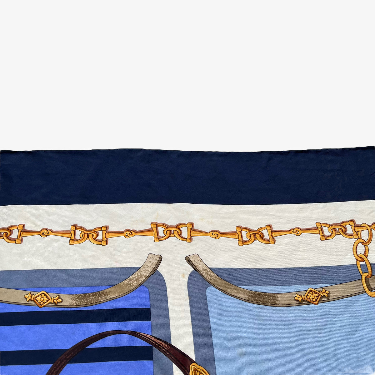 Horsebit chain on women's vintage 90s Lancel Paris gold equestrian print blue silk scarf featuring a striped design.
