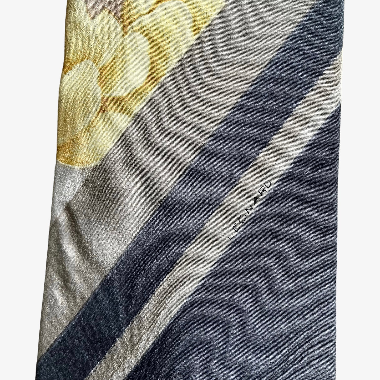 Close up of logo on vintage 90s Leonard striped abstract floral print silk tie.