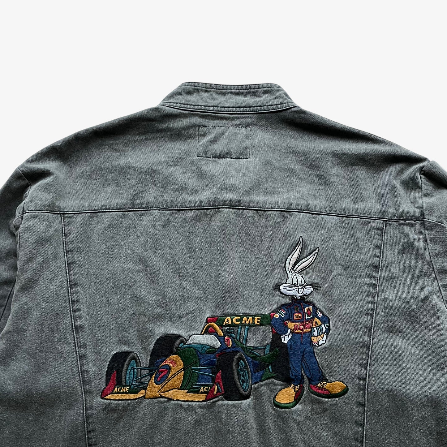 Close up of a Bugs Bunny nascar embroidery on the back of a vintage 90s men's ACME Warner Bros Looney Tunes grey racing jacket.