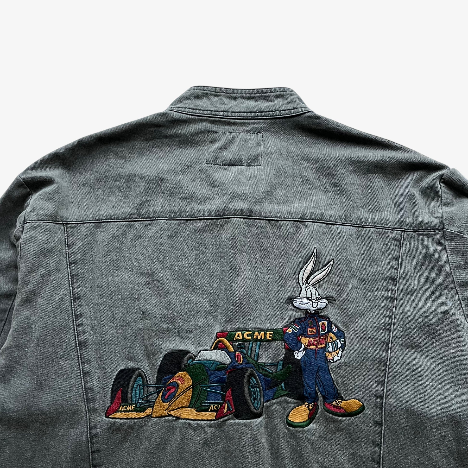 Close up of a Bugs Bunny nascar embroidery on the back of a vintage 90s men's ACME Warner Bros Looney Tunes grey racing jacket.