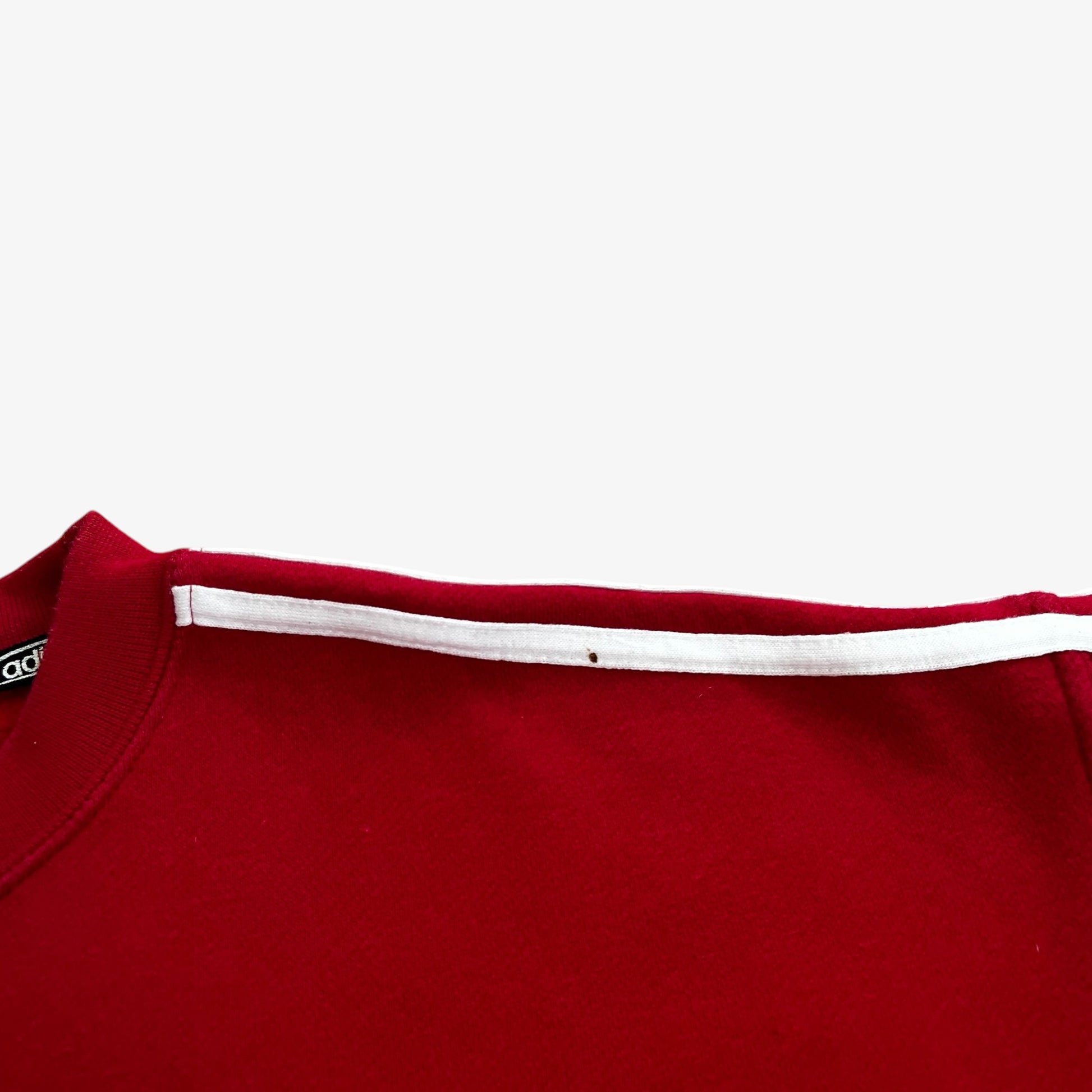 Close up of patina on a red Adidas sweatshirt.