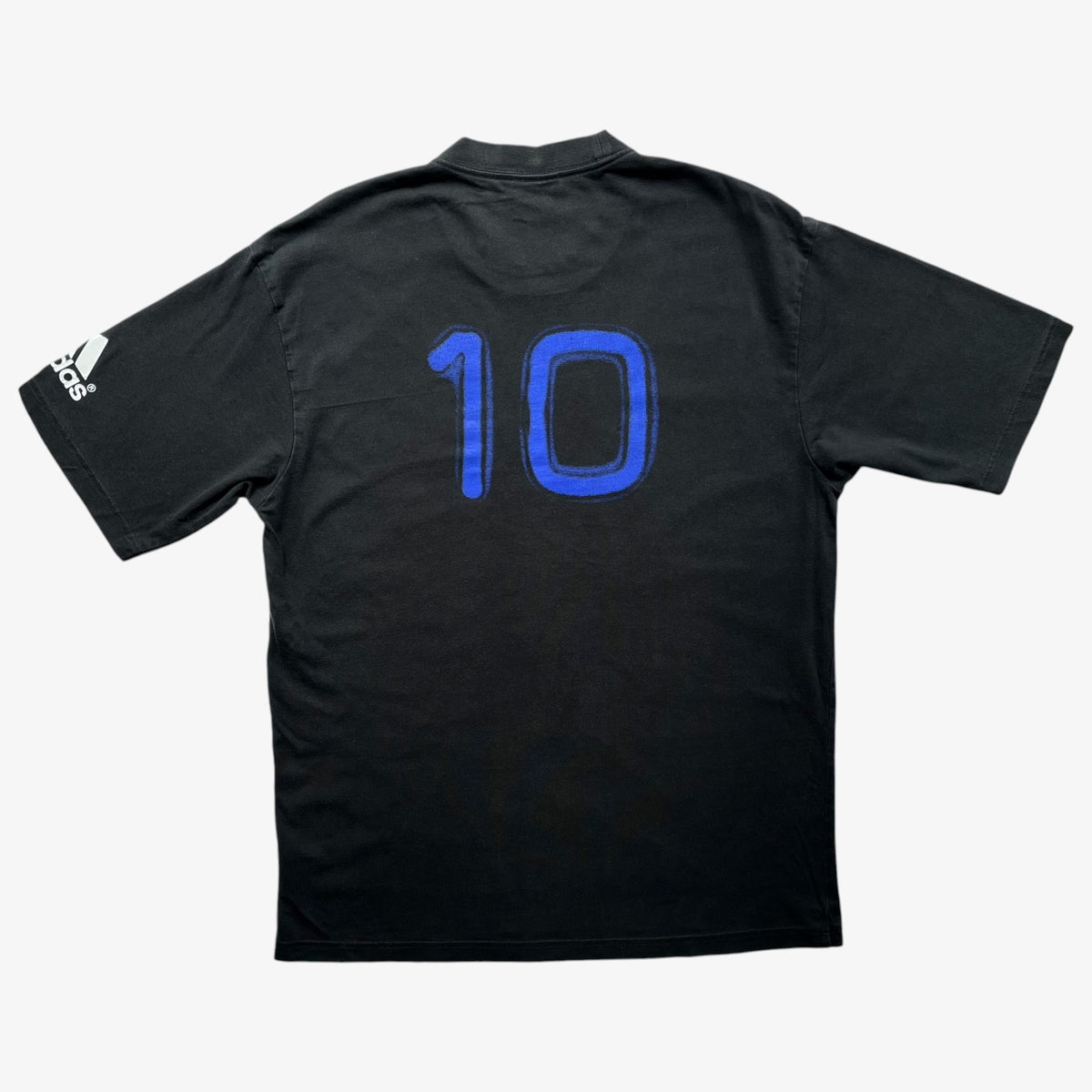 Vintage Adidas black short-sleeve t-shirt shown from the back, featuring the number 10 in blue on the back and a white Adidas logo on the sleeve, set against a light grey background.