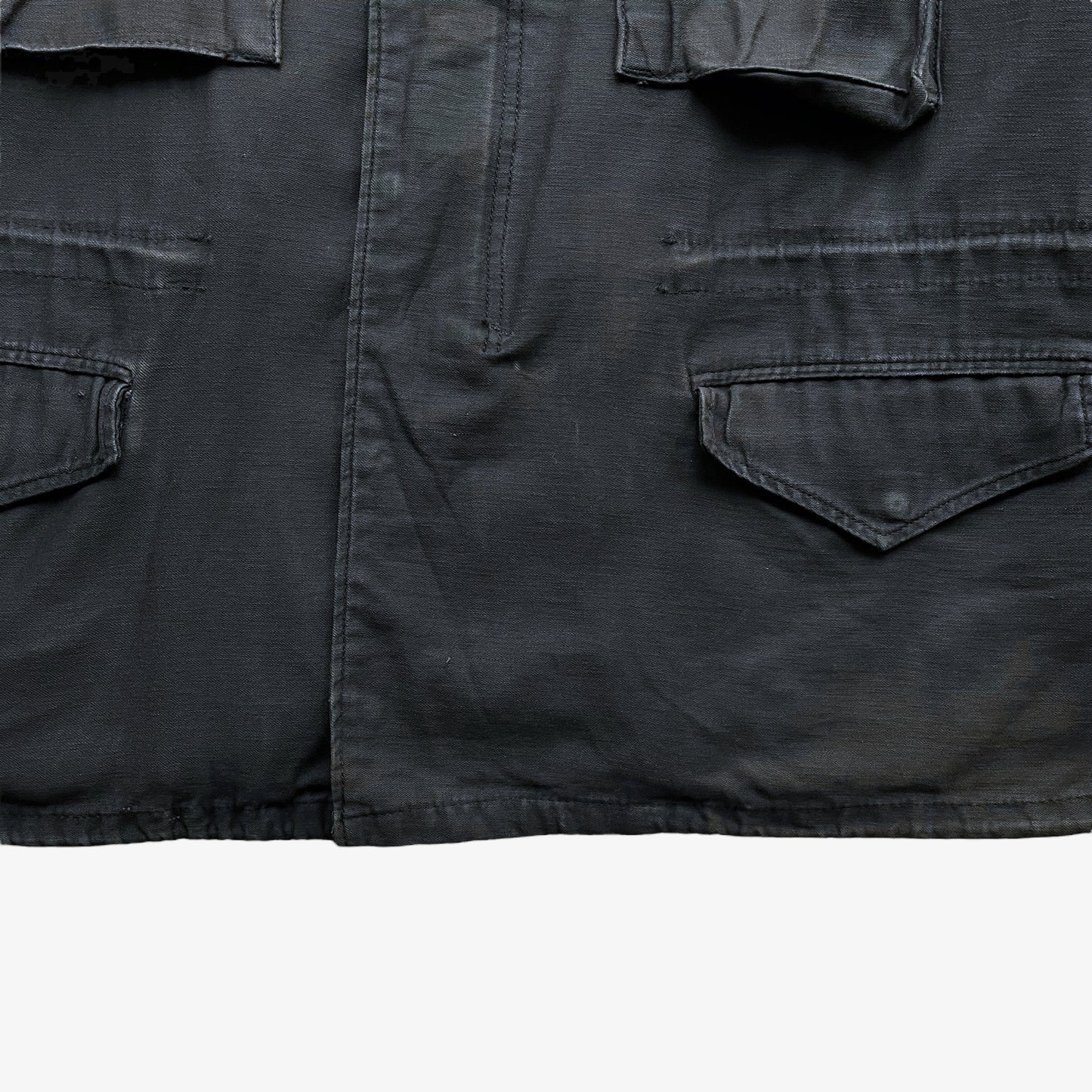 Hem of vintage 90s men's Alpha Industries brown M65 cold weather field jacket.