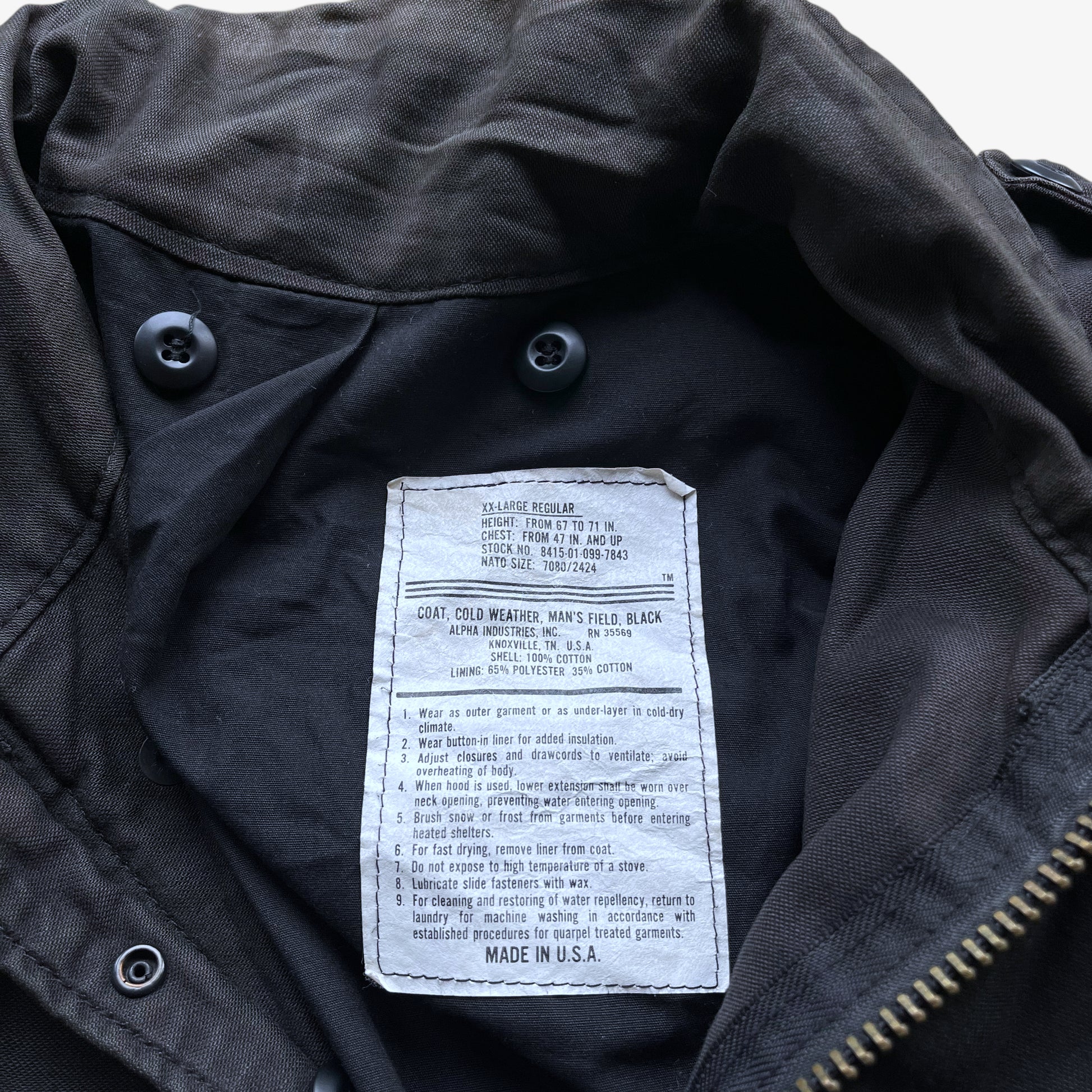 Alpha Industries label stitched inside of a vintage 90s men's brown M65 cold weather field jacket.