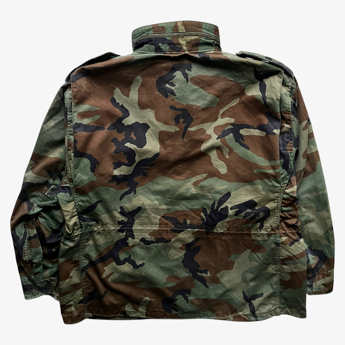 Back of vintage 90s men's Alpha Industries M65 cold weather green camouflage field jacket.