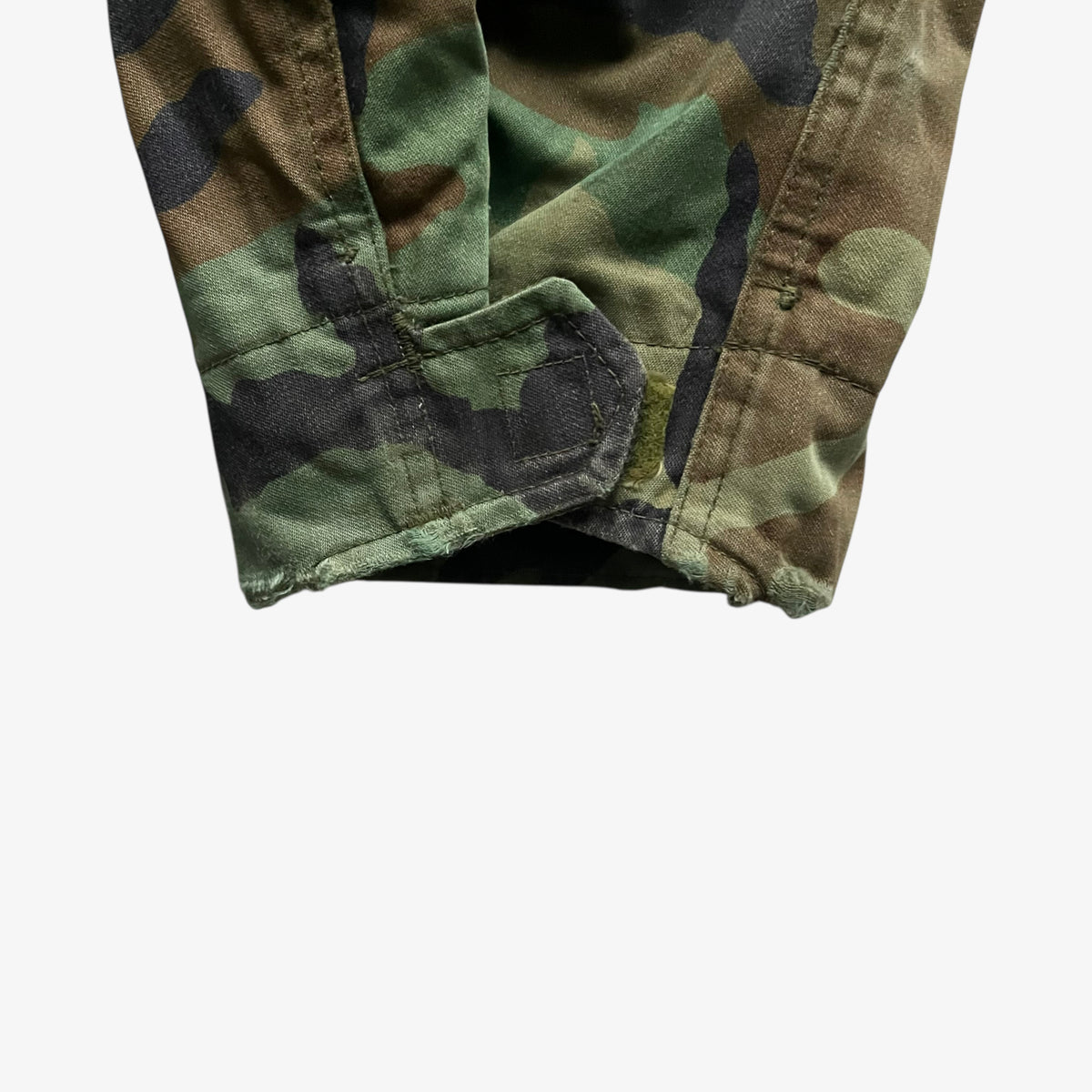 Cuff of vintage 90s men's Alpha Industries M65 cold weather green camouflage field jacket.