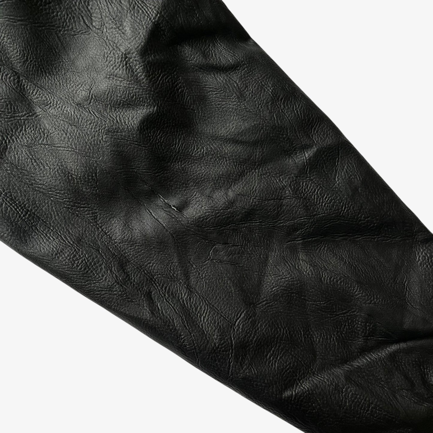 Patina on the sleeve of vintage 90s men's American Cheer Power national champion wool blend black varsity jacket.