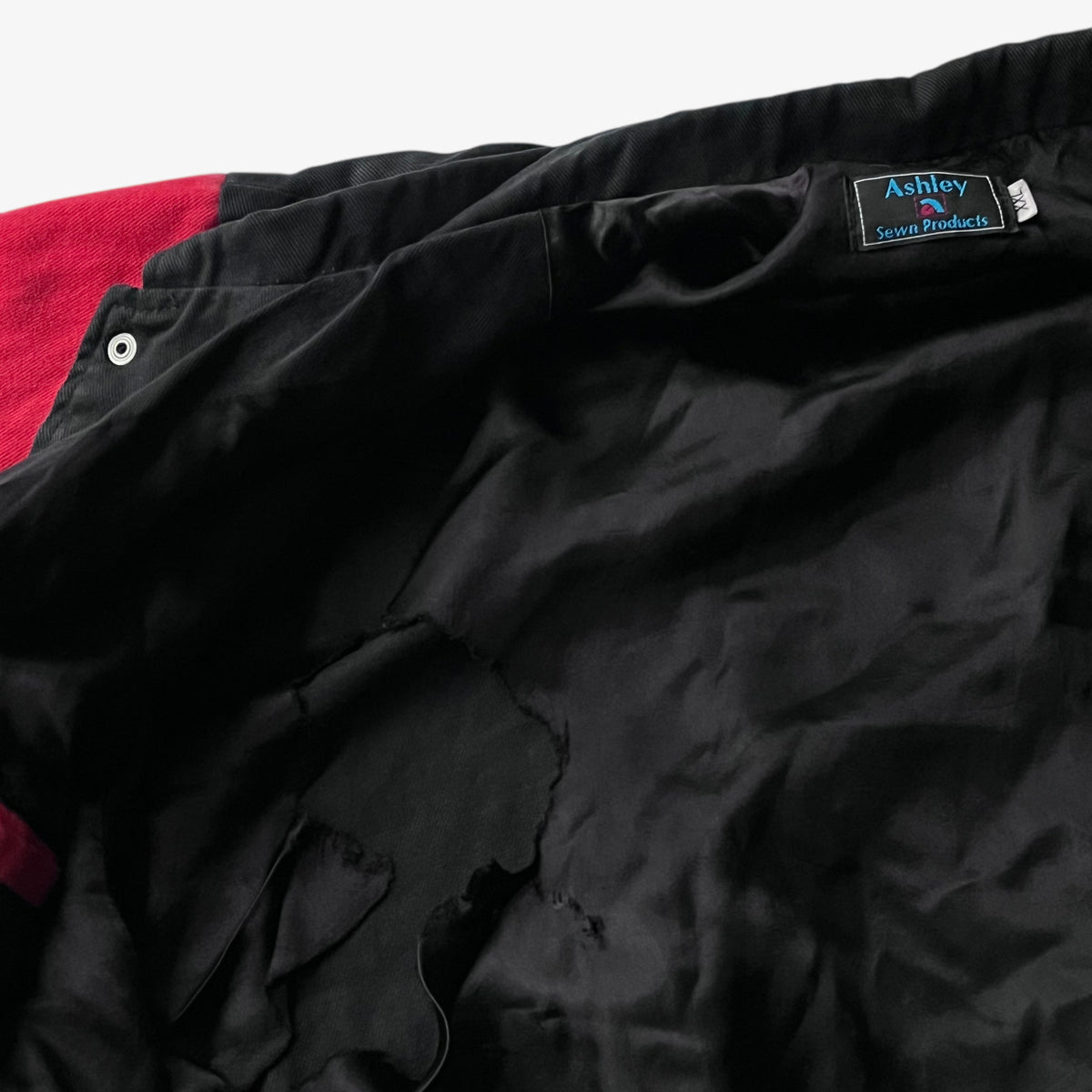 Ripped lining of vintage 90s men's Ashley UPS black and red nascar jacket.
