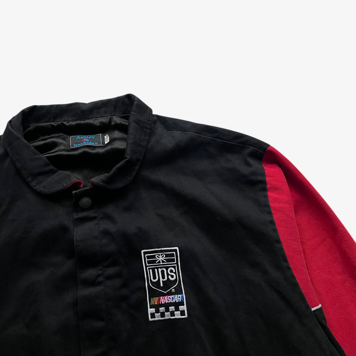 Chest embroidered spell out on vintage 90s men's Ashley UPS black and red nascar jacket.
