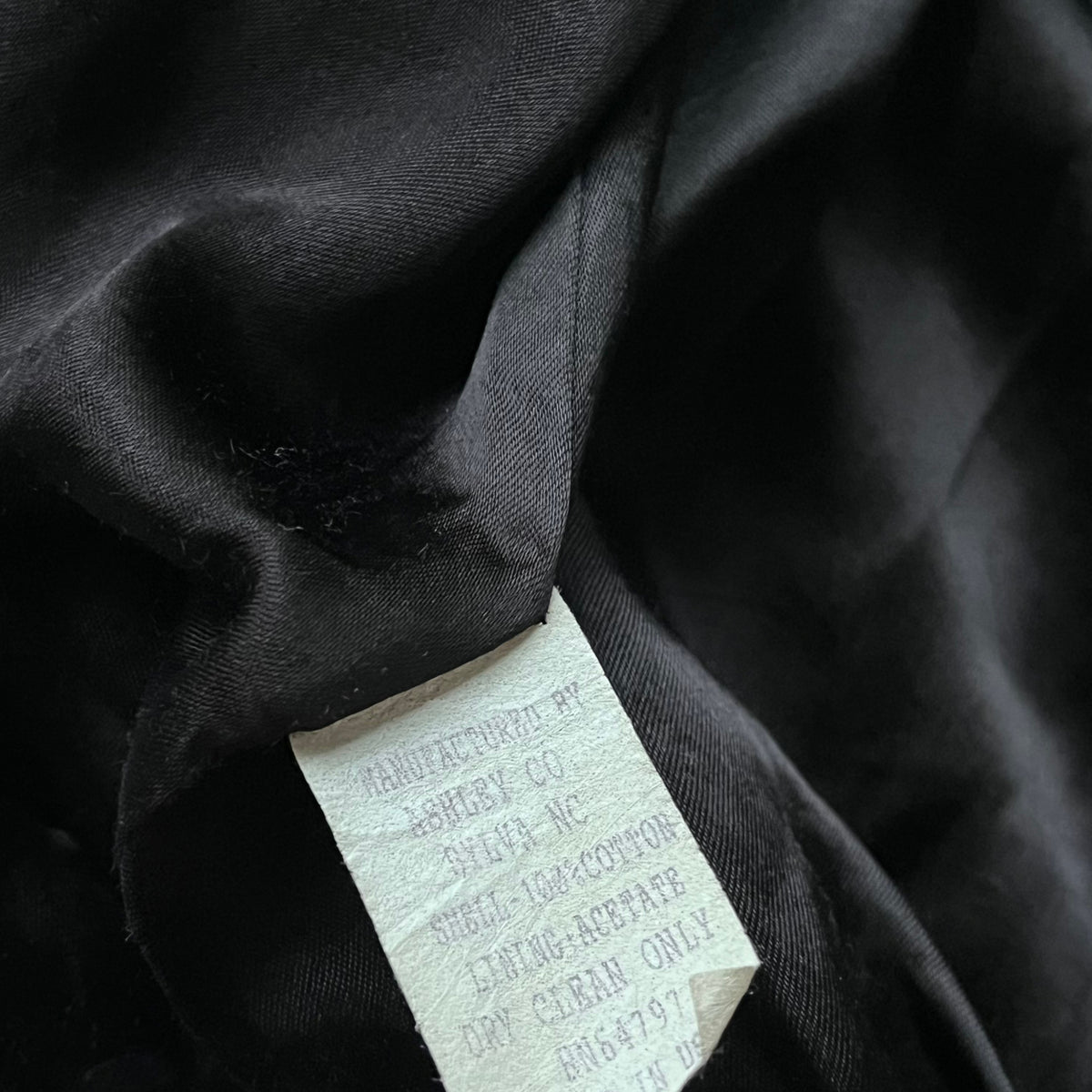 Made in USA label stitched inside of a vintage 90s men's Ashley UPS black and red nascar jacket.