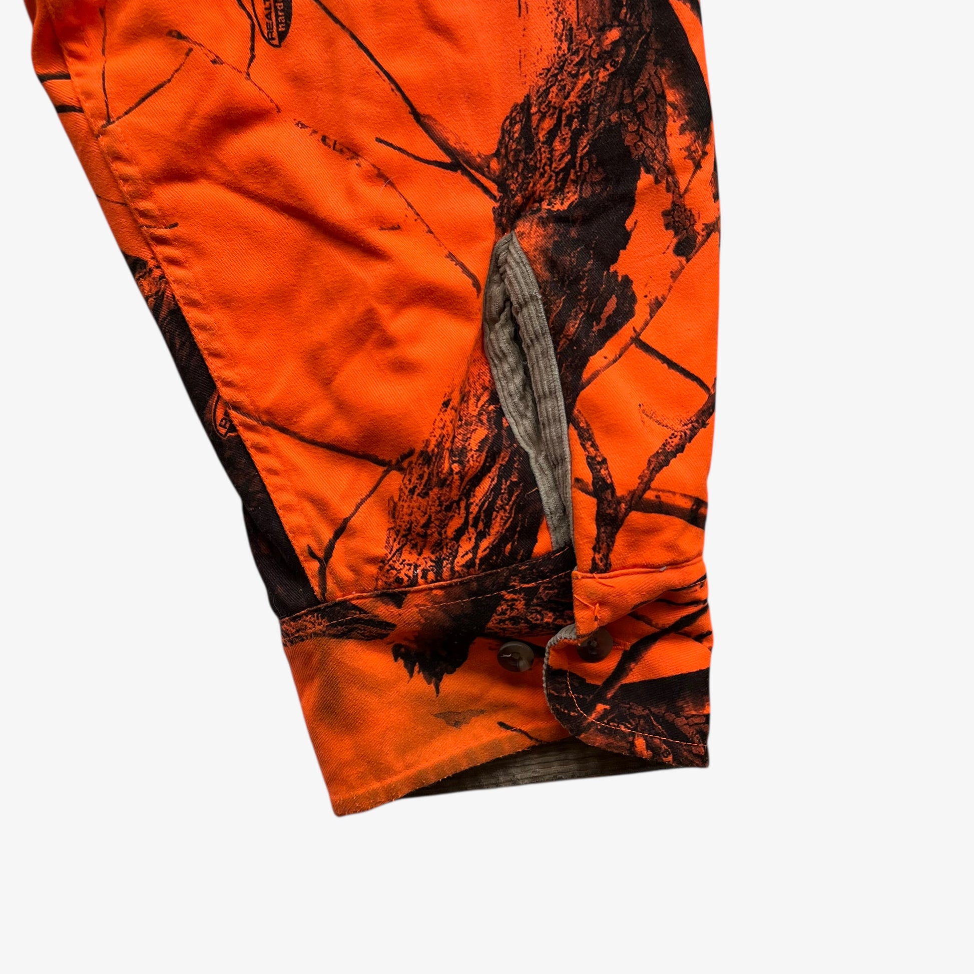 Sleeve of vintage 90s men's Cabela's real tree hardwoods orange camouflage hunting jacket.