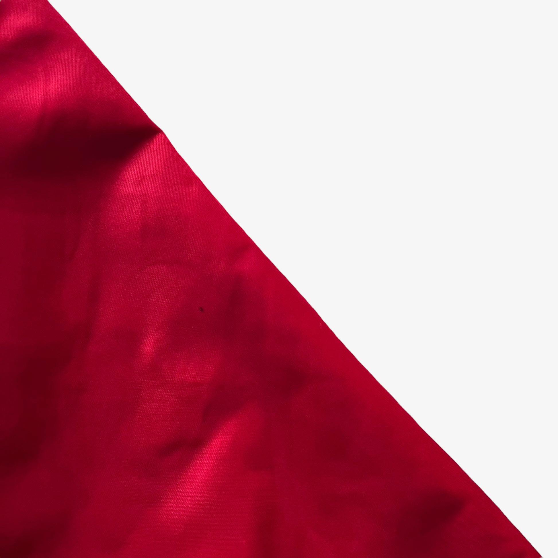 Arm of men's vintage 90s Chalk Line NBA Chicago Bulls red varsity jacket with back embroidered spell out.