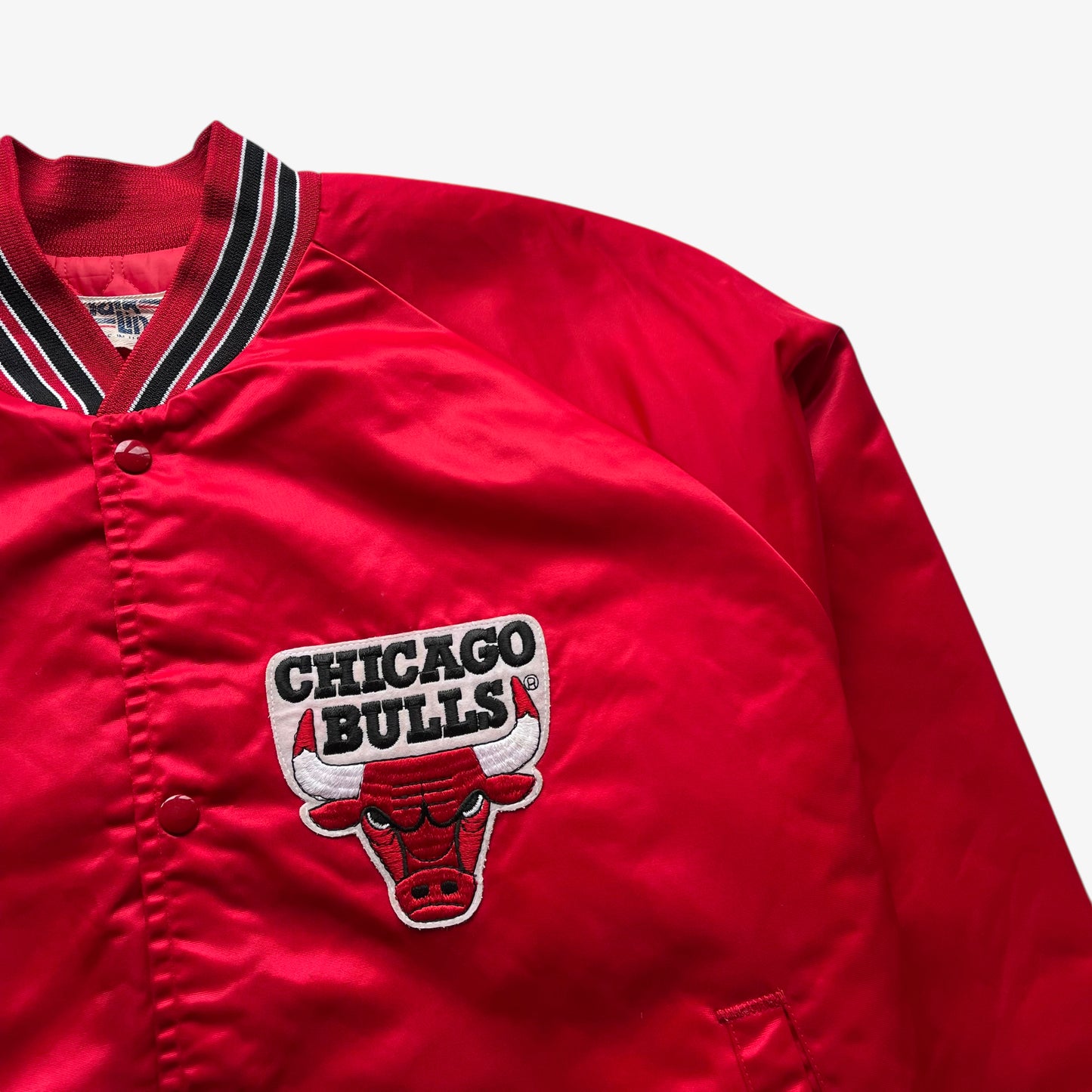 Embroidered Chicago Bulls badge on men's vintage 90s Chalk Line NBA red varsity jacket with back embroidered spell out.