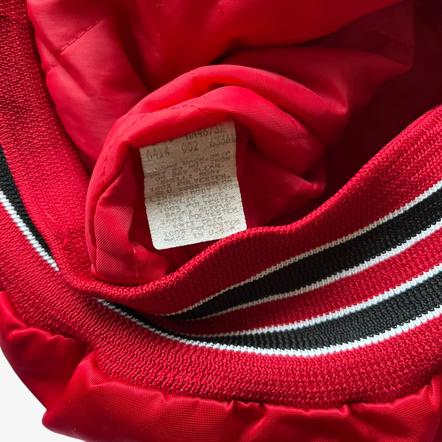 Made in USA label of men's vintage 90s Chalk Line NBA Chicago Bulls red varsity jacket with back embroidered spell out.