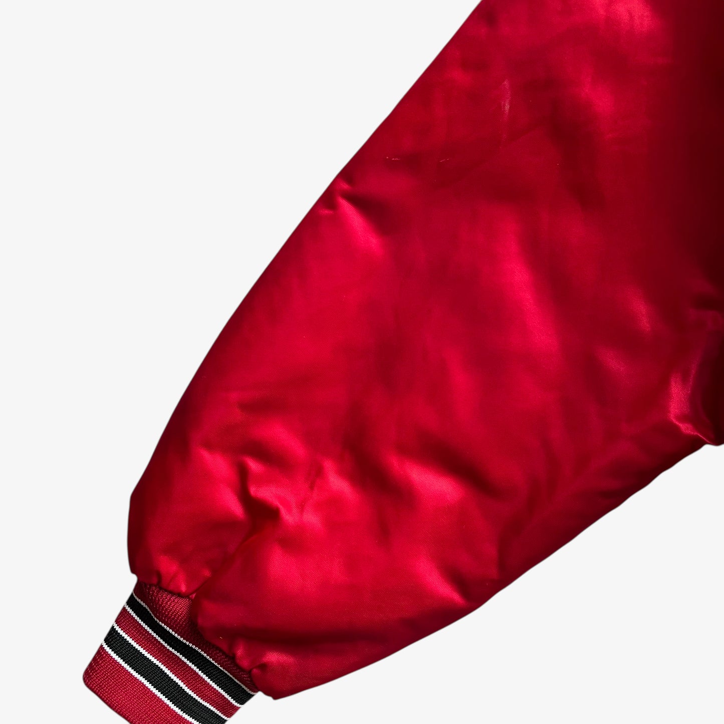 Wear on sleeve of men's vintage 90s Chalk Line NBA Chicago Bulls red varsity jacket with back embroidered spell out.