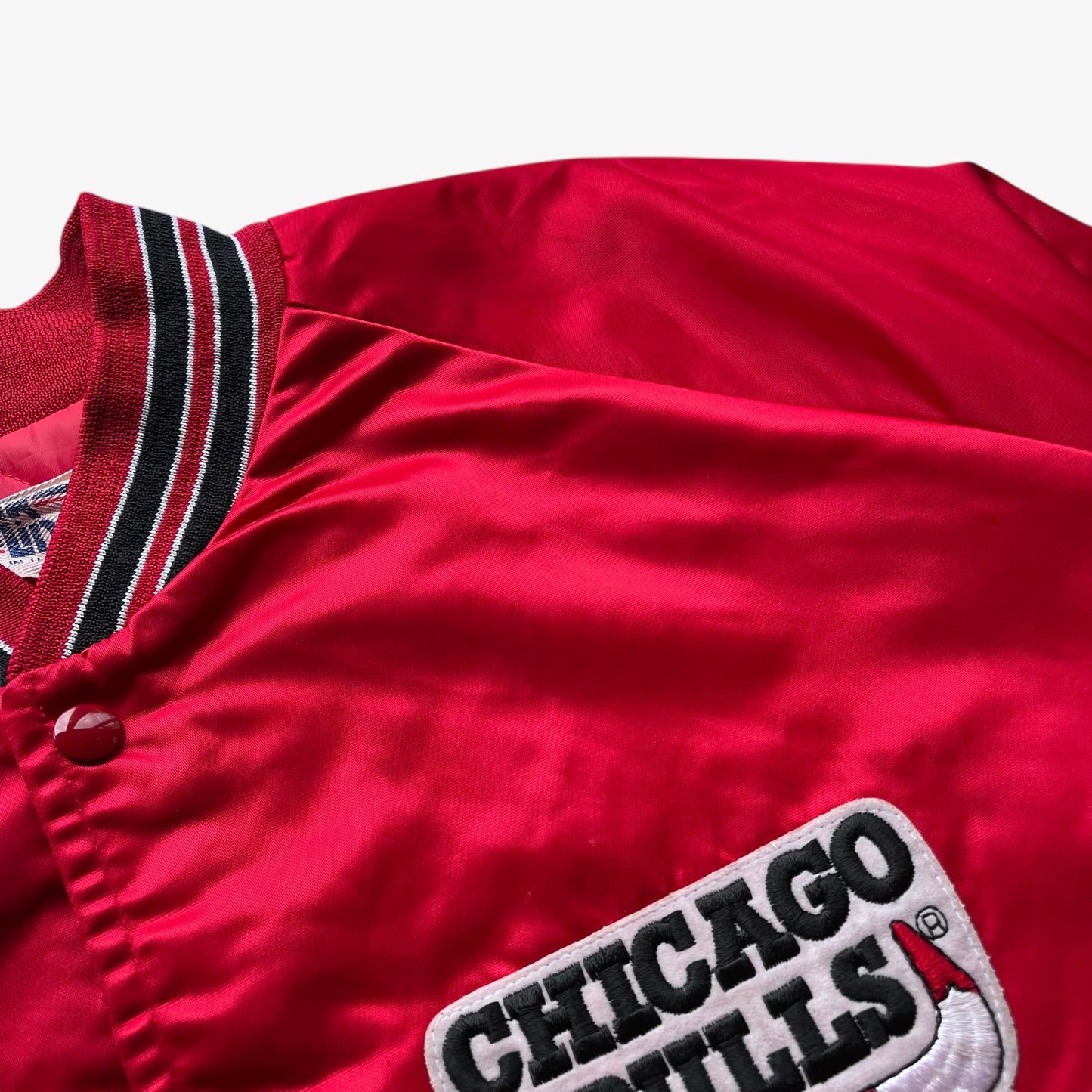 Wear on men's vintage 90s Chalk Line NBA Chicago Bulls red varsity jacket with back embroidered spell out.