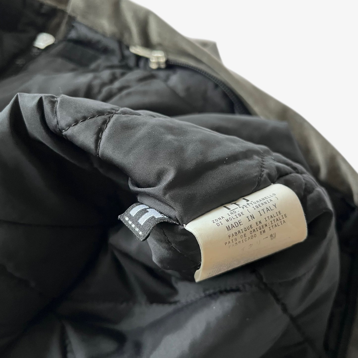 Made in Italy label stitched inside of a vintage 90s men's Gianfranco Ferre Jeans khaki ribbed jacket.