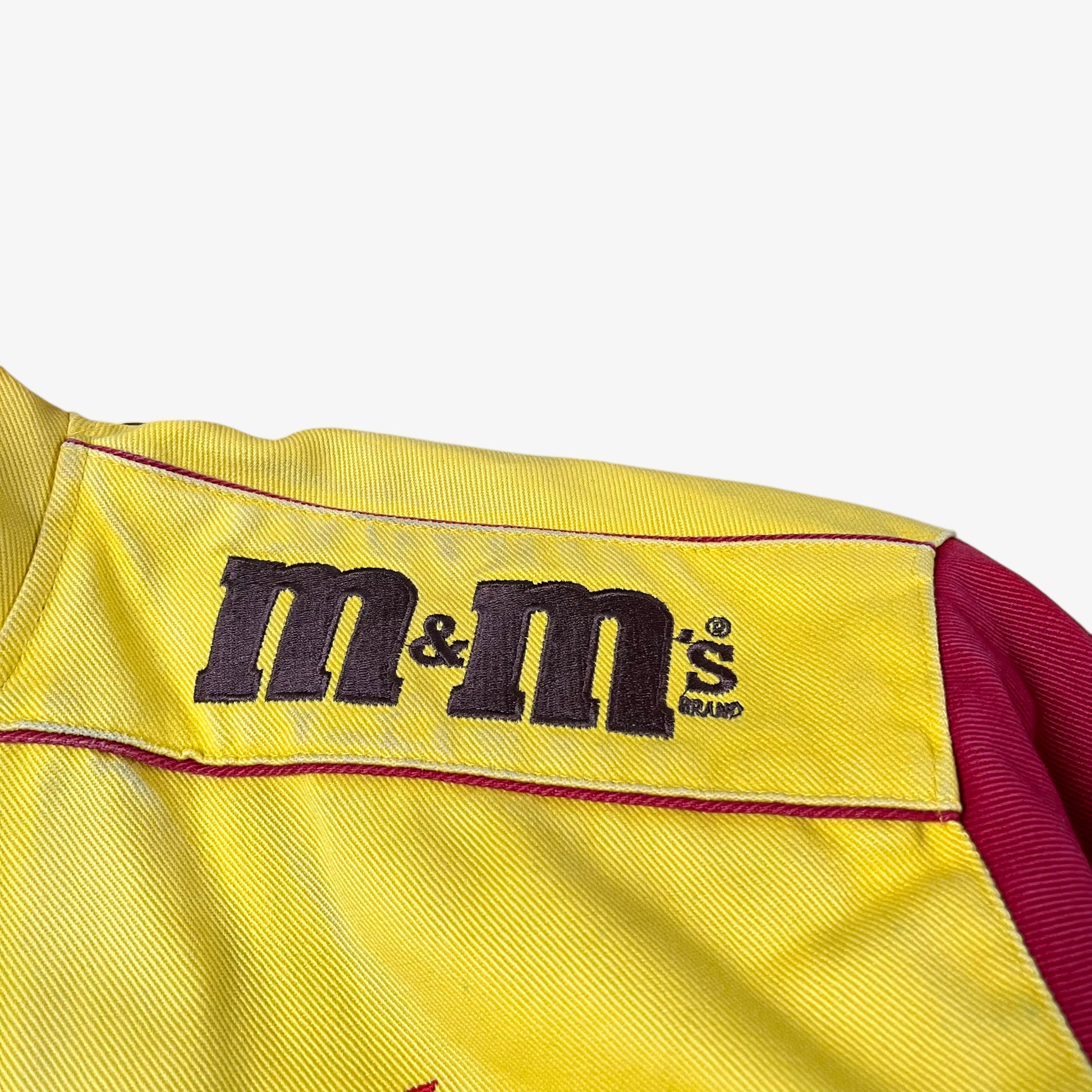 Shoulder of vintage 90s Jeff Hamilton JH Design Ernie Irvan 36 M&M yellow NASCAR jacket.