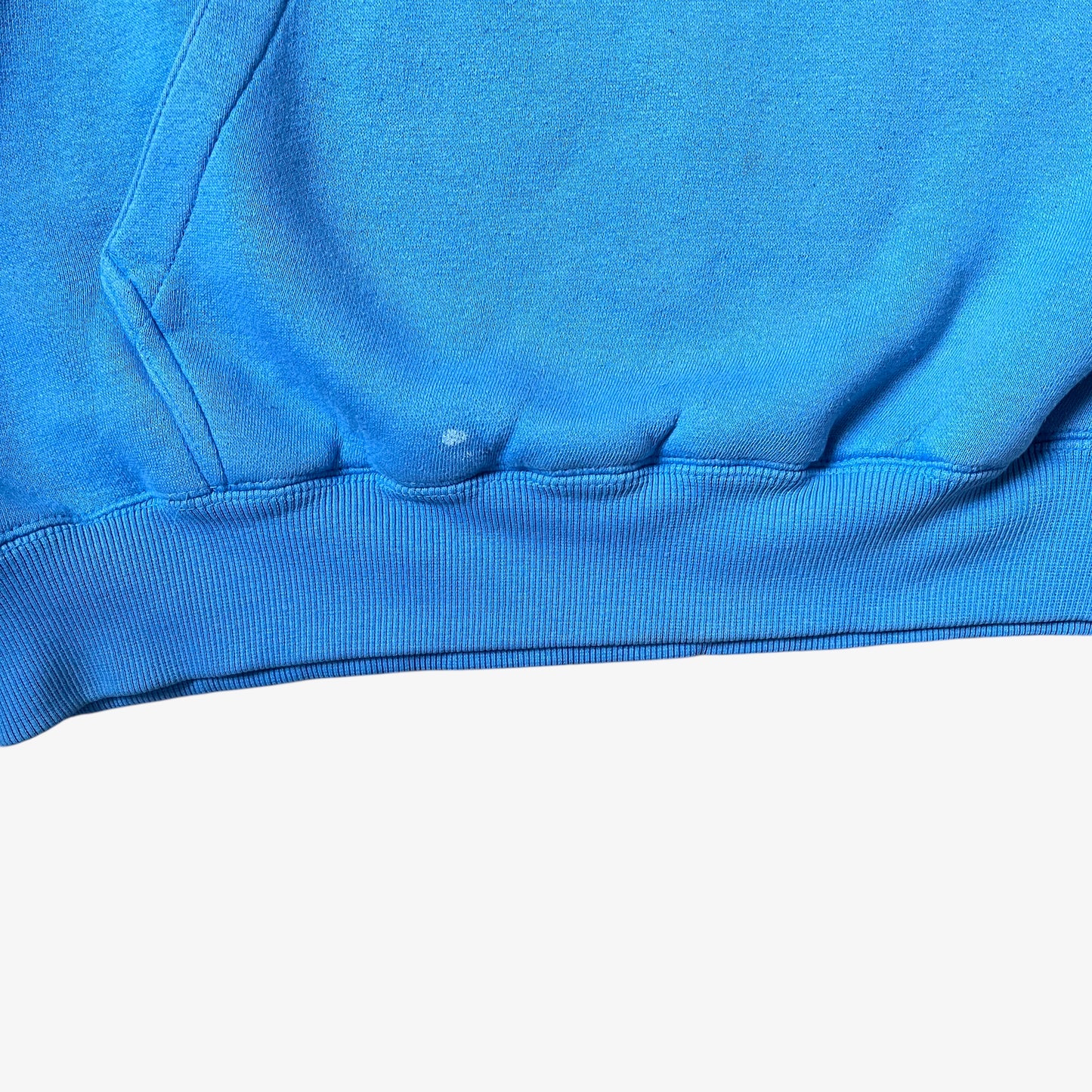 Ribbed hem of a vintage 90s men's Johnny Blaze blue hoodie.