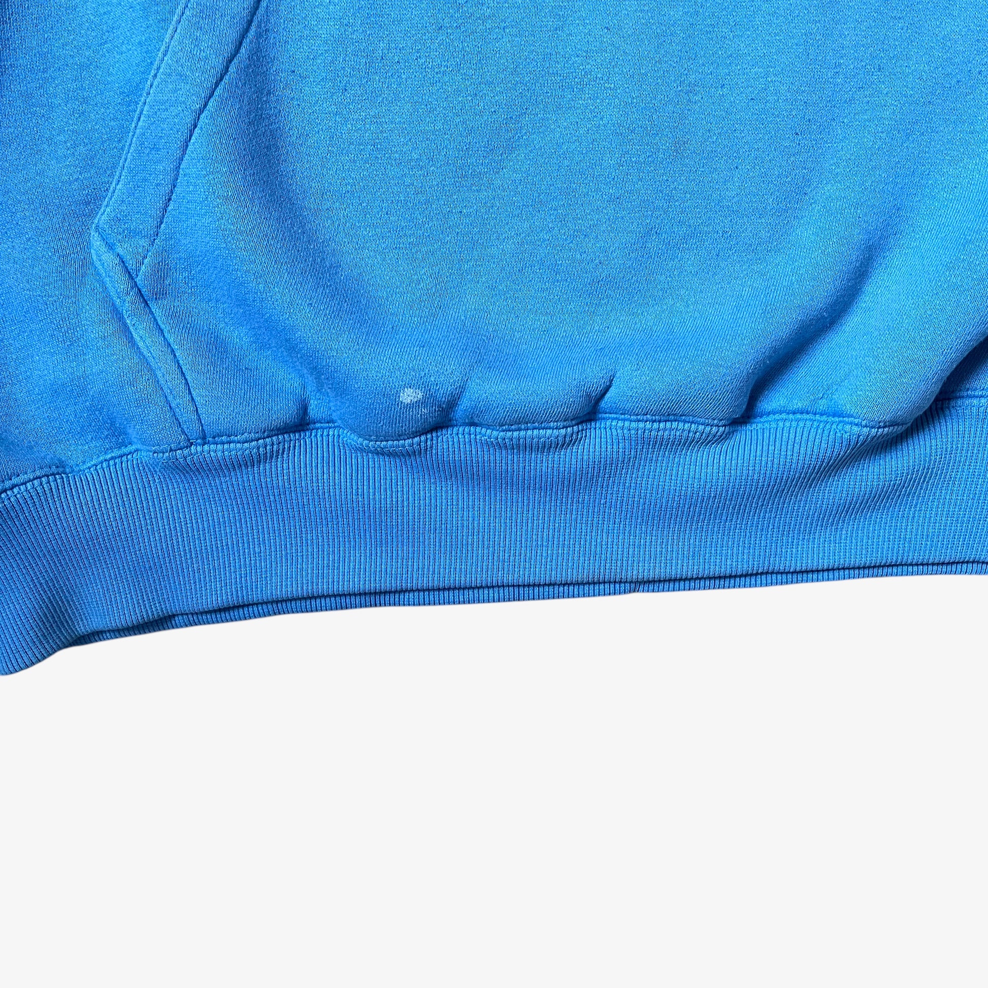 Ribbed hem of a vintage 90s men's Johnny Blaze blue hoodie.