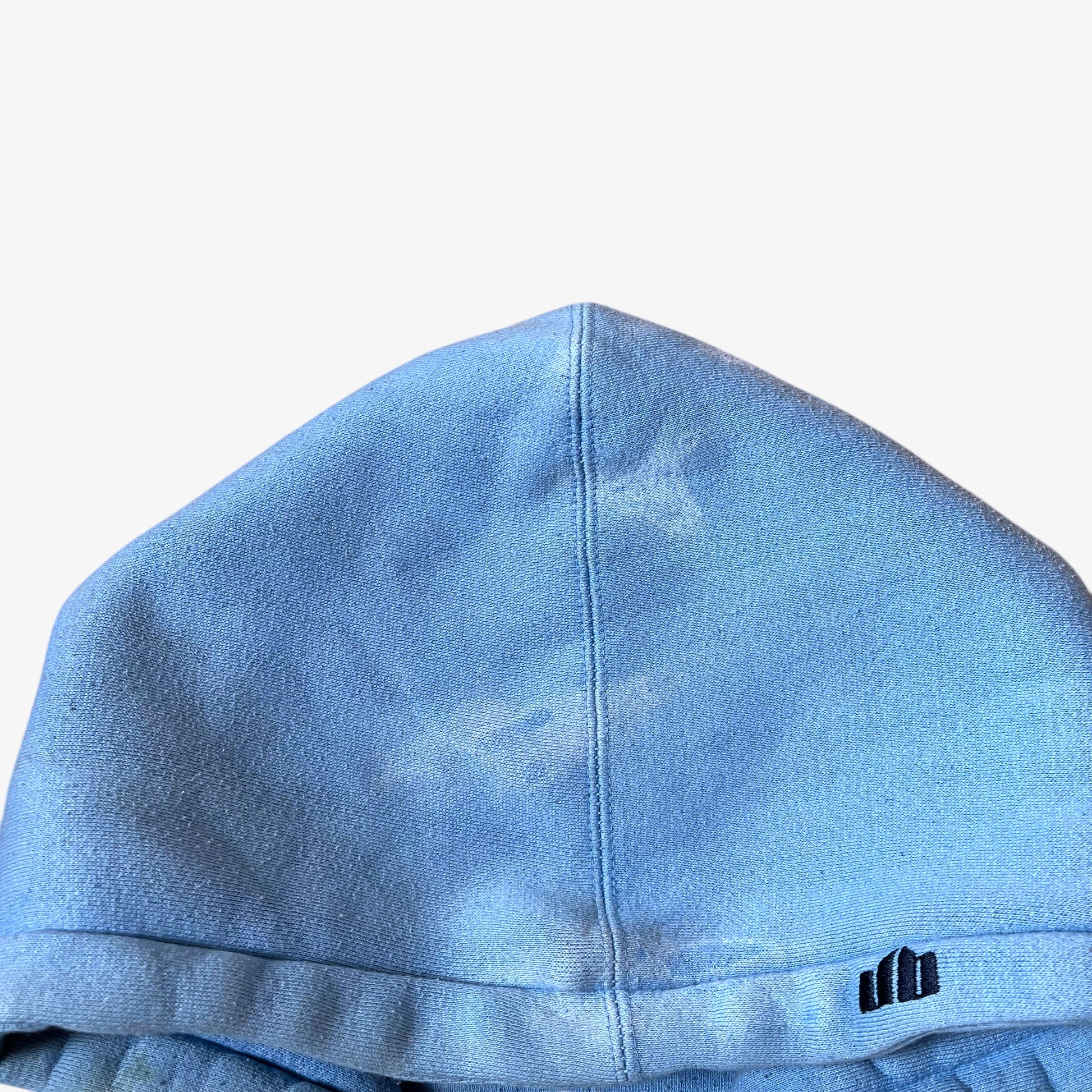 Patina on the hood of a vintage 90s men's Johnny Blaze blue hoodie.