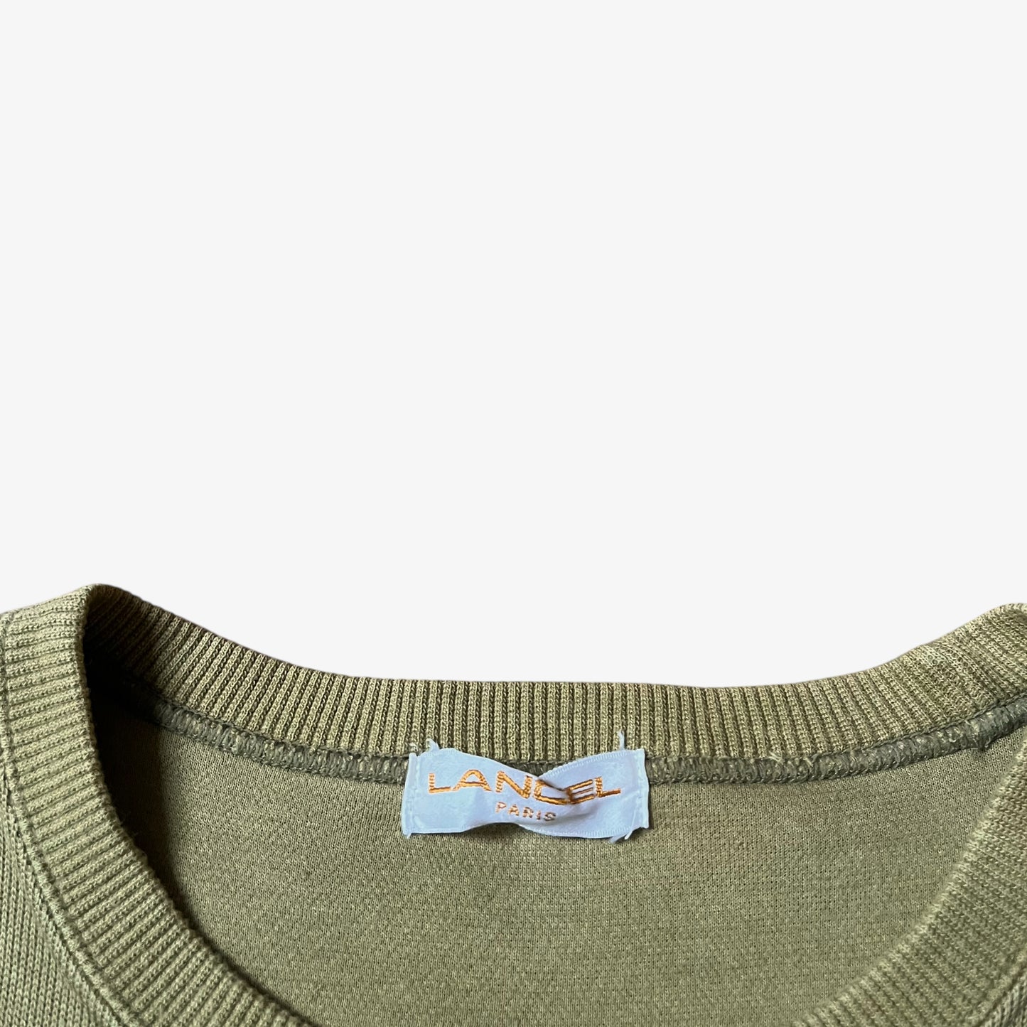 Lancel Paris label stitched inside of a vintage 90s men's green sweatshirt.