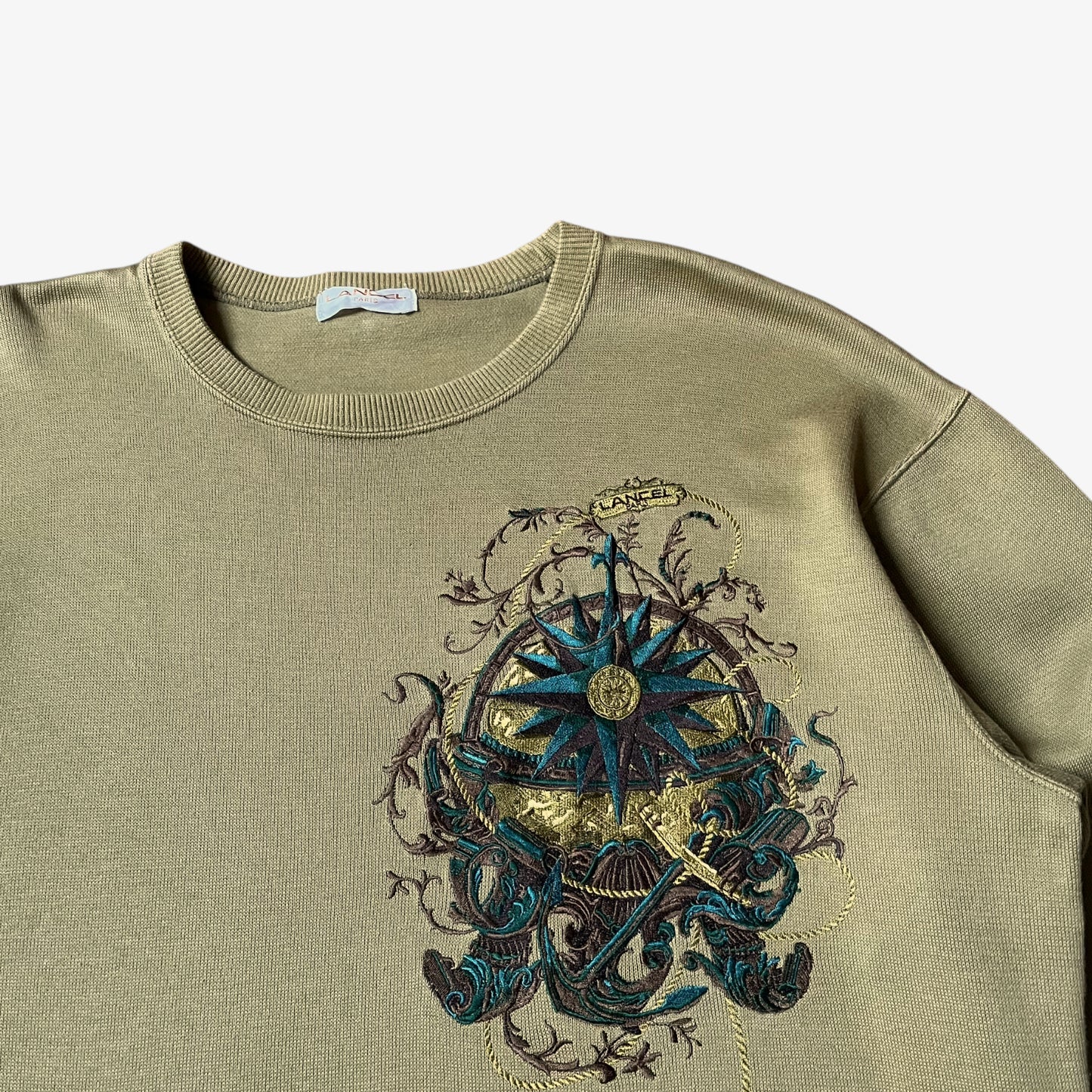Close up of embroidered nautical pattern on a vintage 90s men's Lancel Paris green sweatshirt.