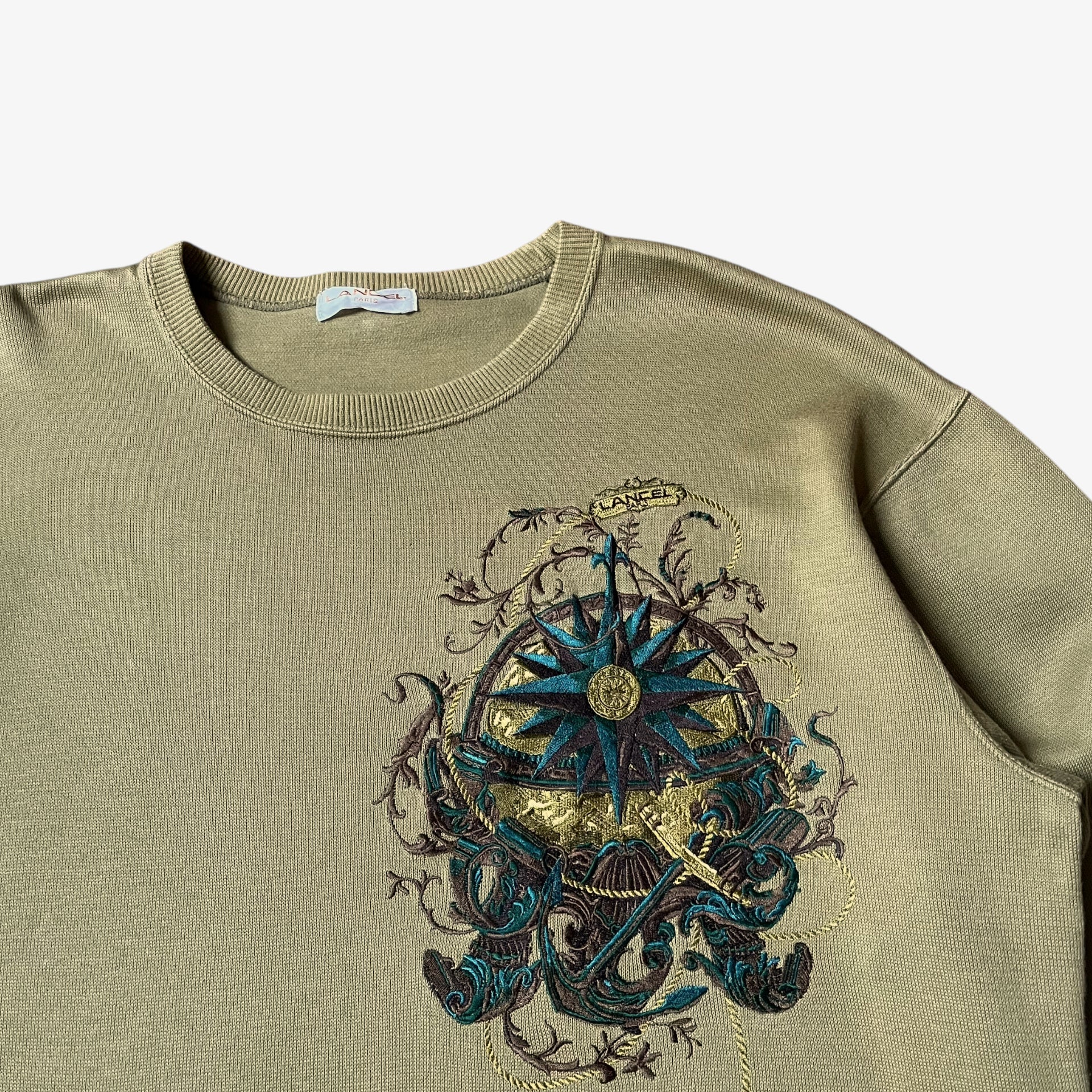 Close up of embroidered nautical pattern on a vintage 90s men's Lancel Paris green sweatshirt.